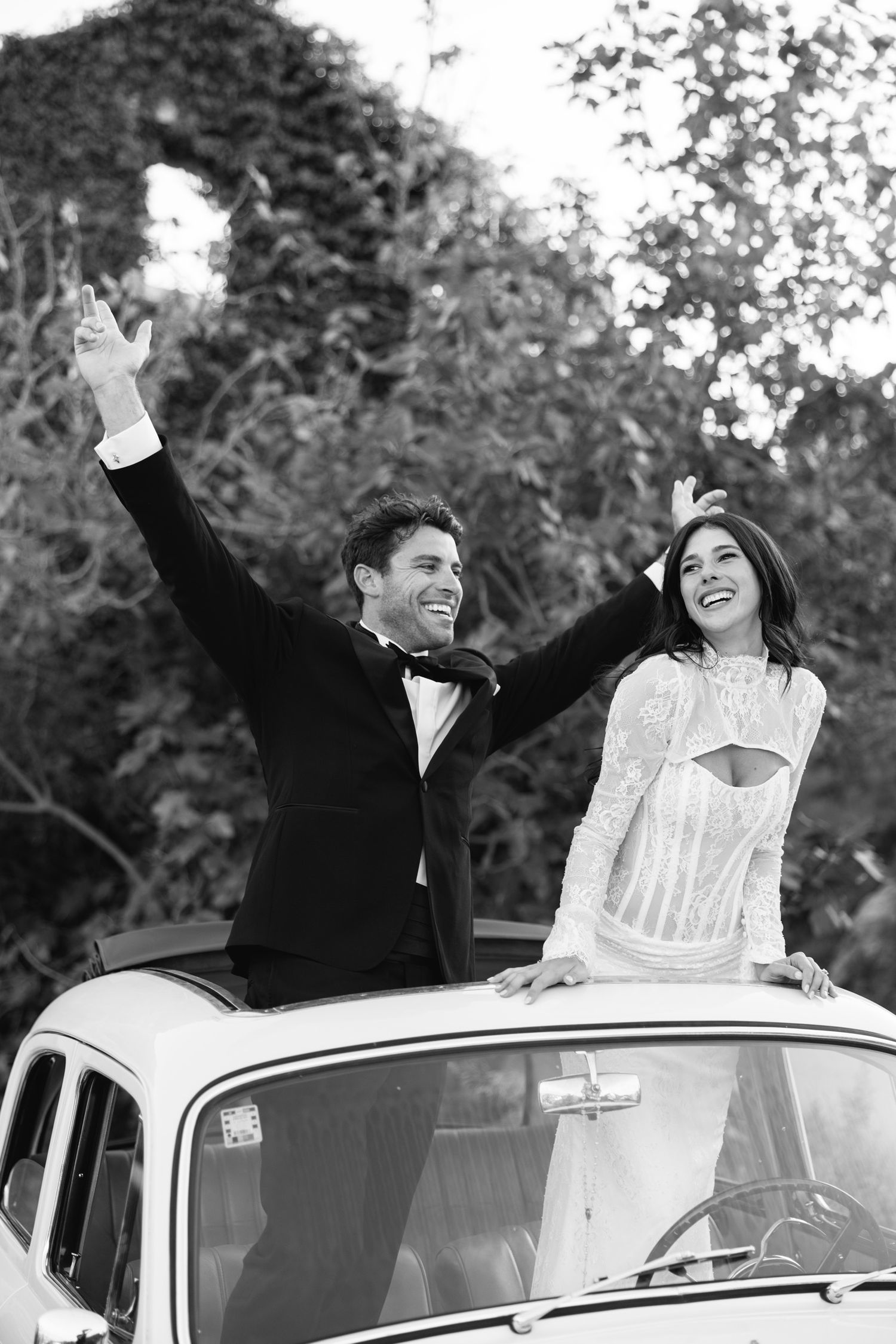 Joyful celebration around a vintage white Mercedes-Benz car in an outdoor setting. Hvar, Croatia