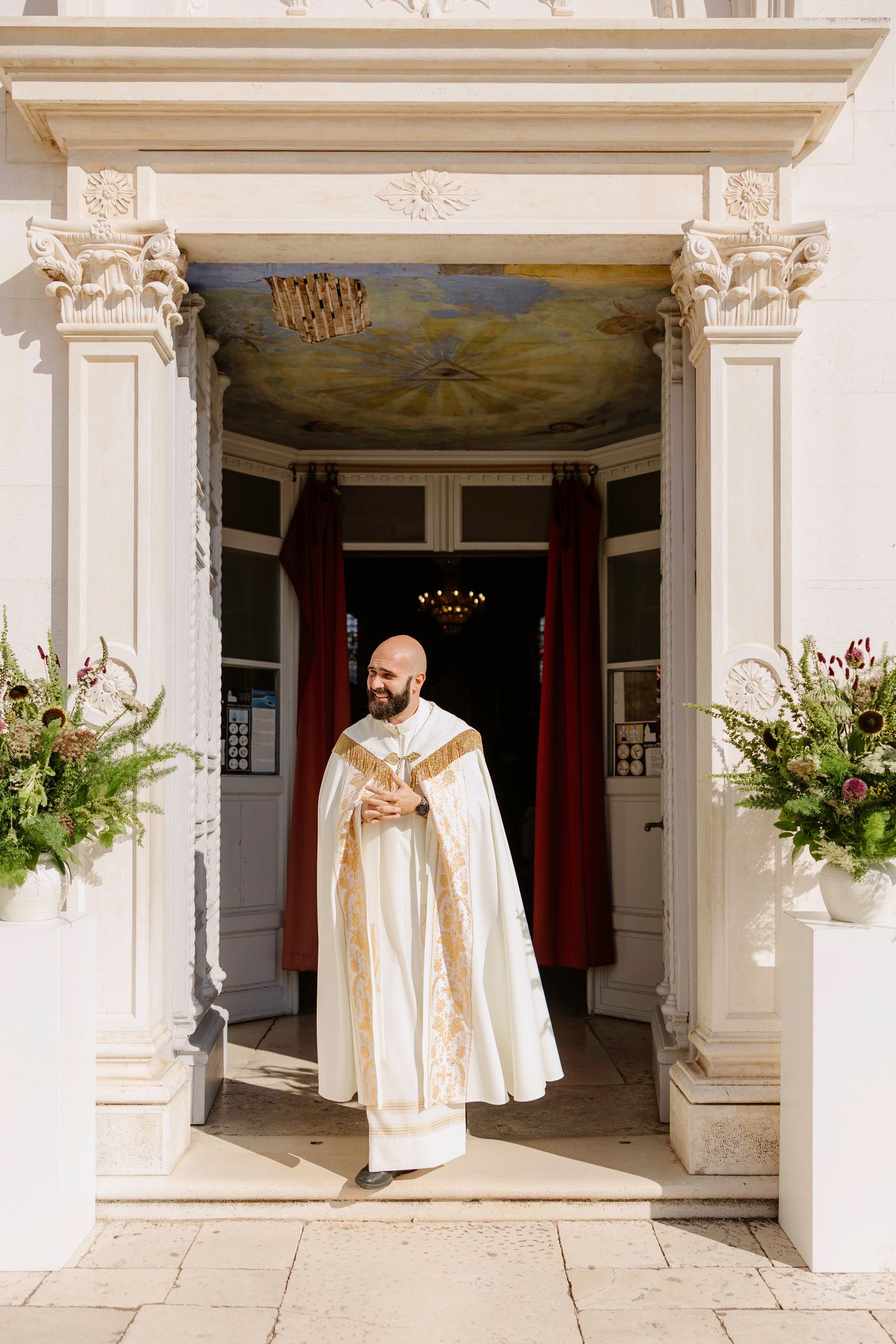 Church entrance decorated with elegant floral arrangements and white decor.
