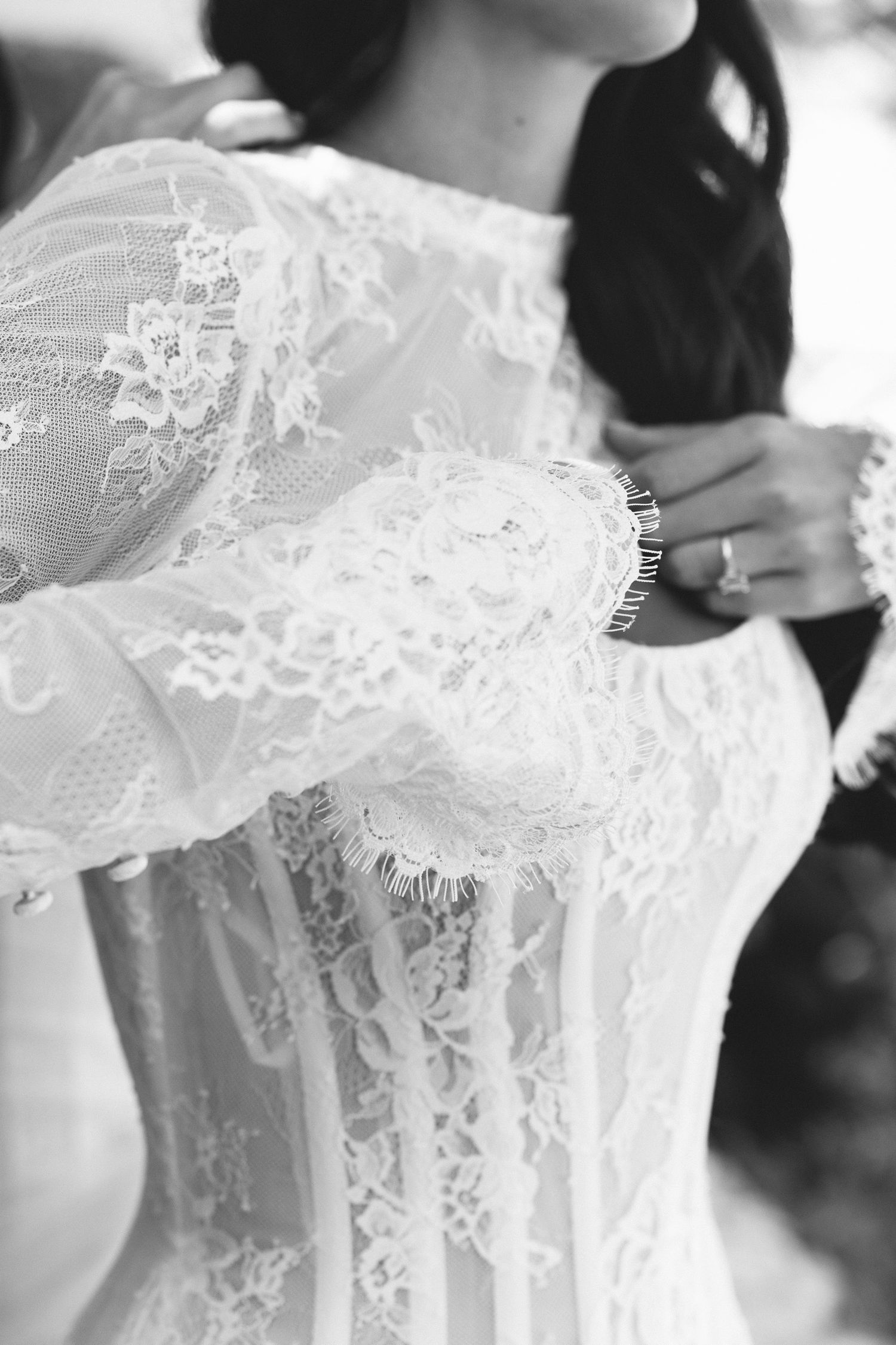 Detailed black and white photograph of intricate lace wedding dress pattern.