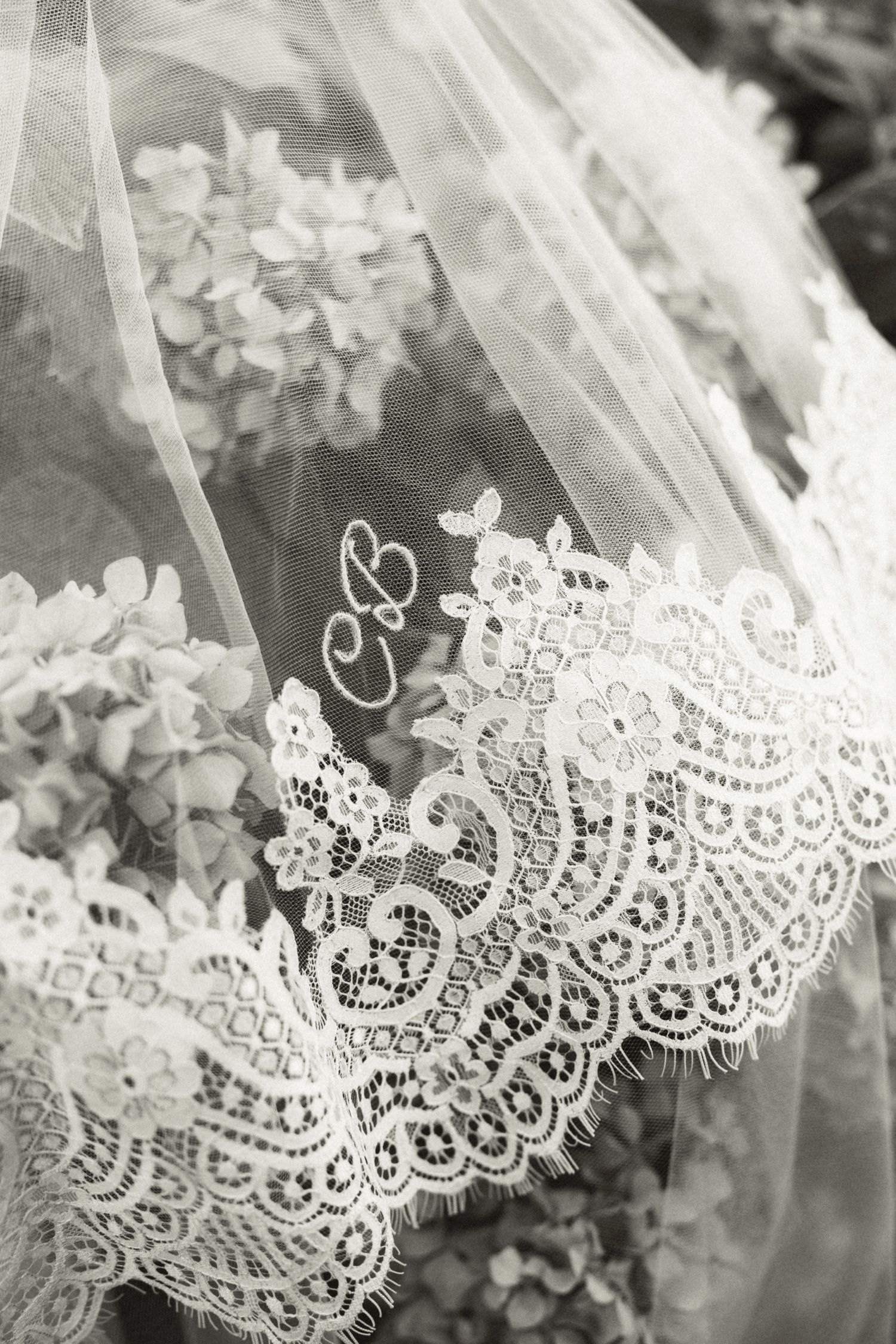 Delicate white lace trim detail with floral pattern shown in black and white photography.