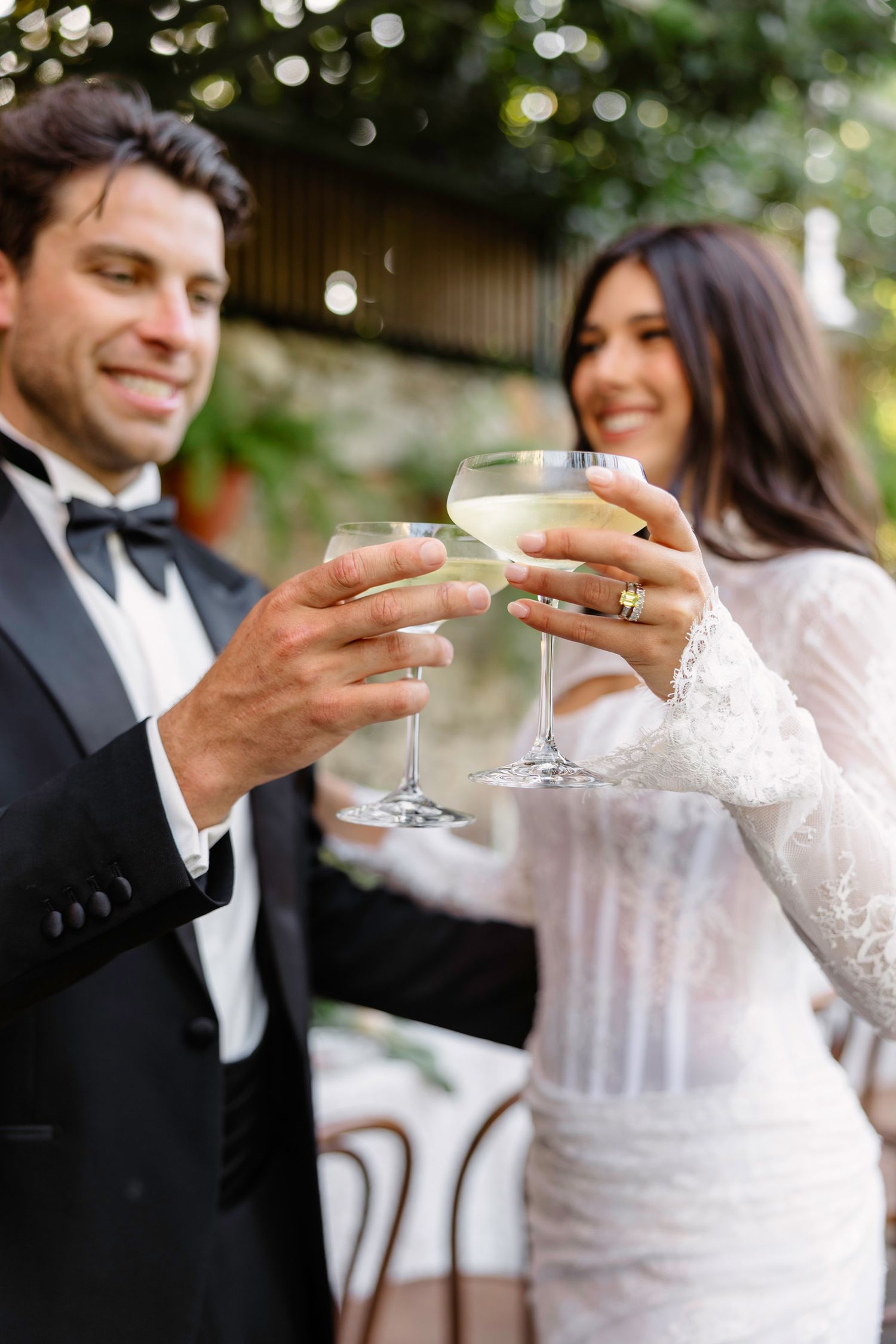 Wedding couple toasting with champagne glasses in an outdoor garden setting. Hvar, Croatia