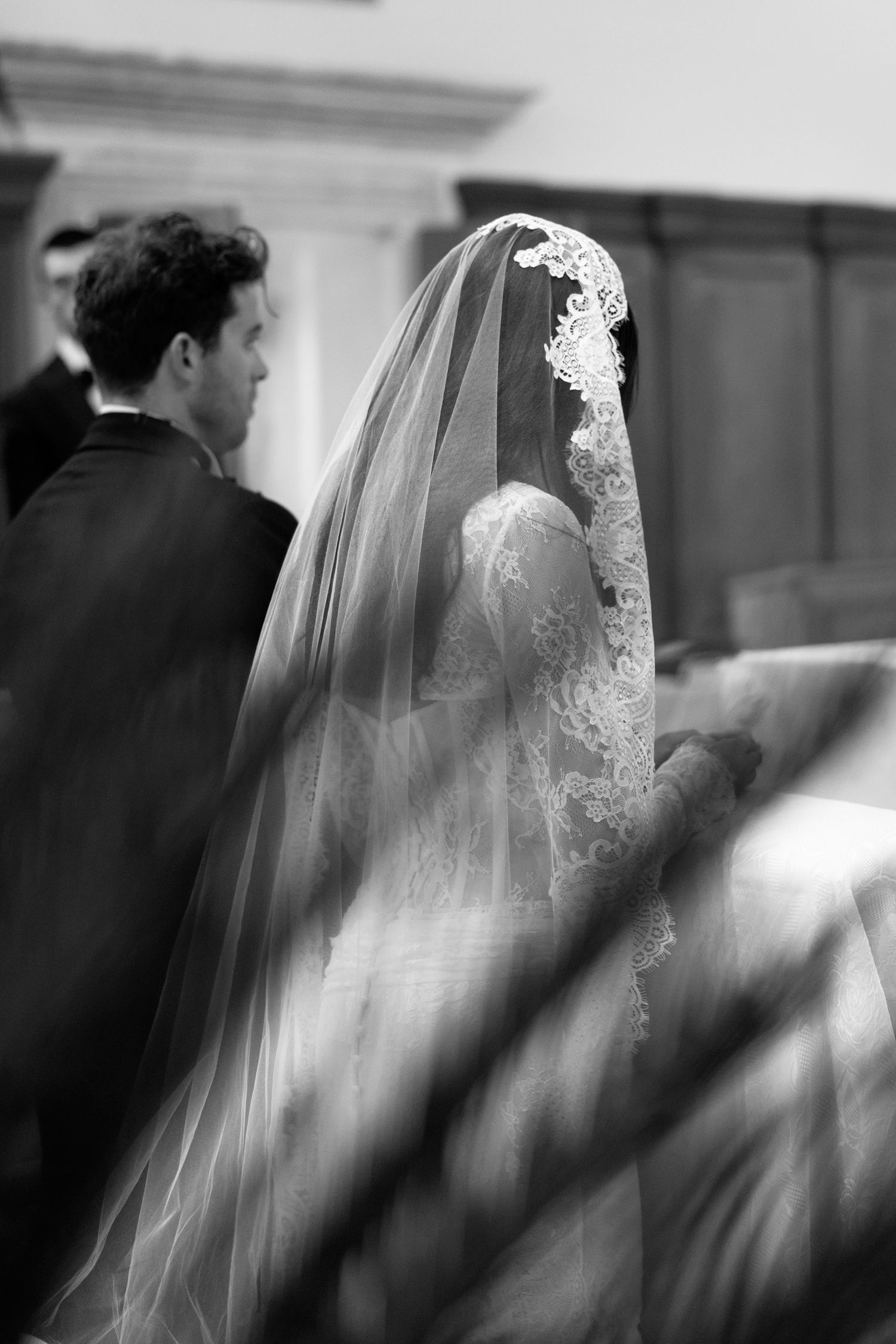 Black and white artistic photo of couple during church wedding ceremony.
