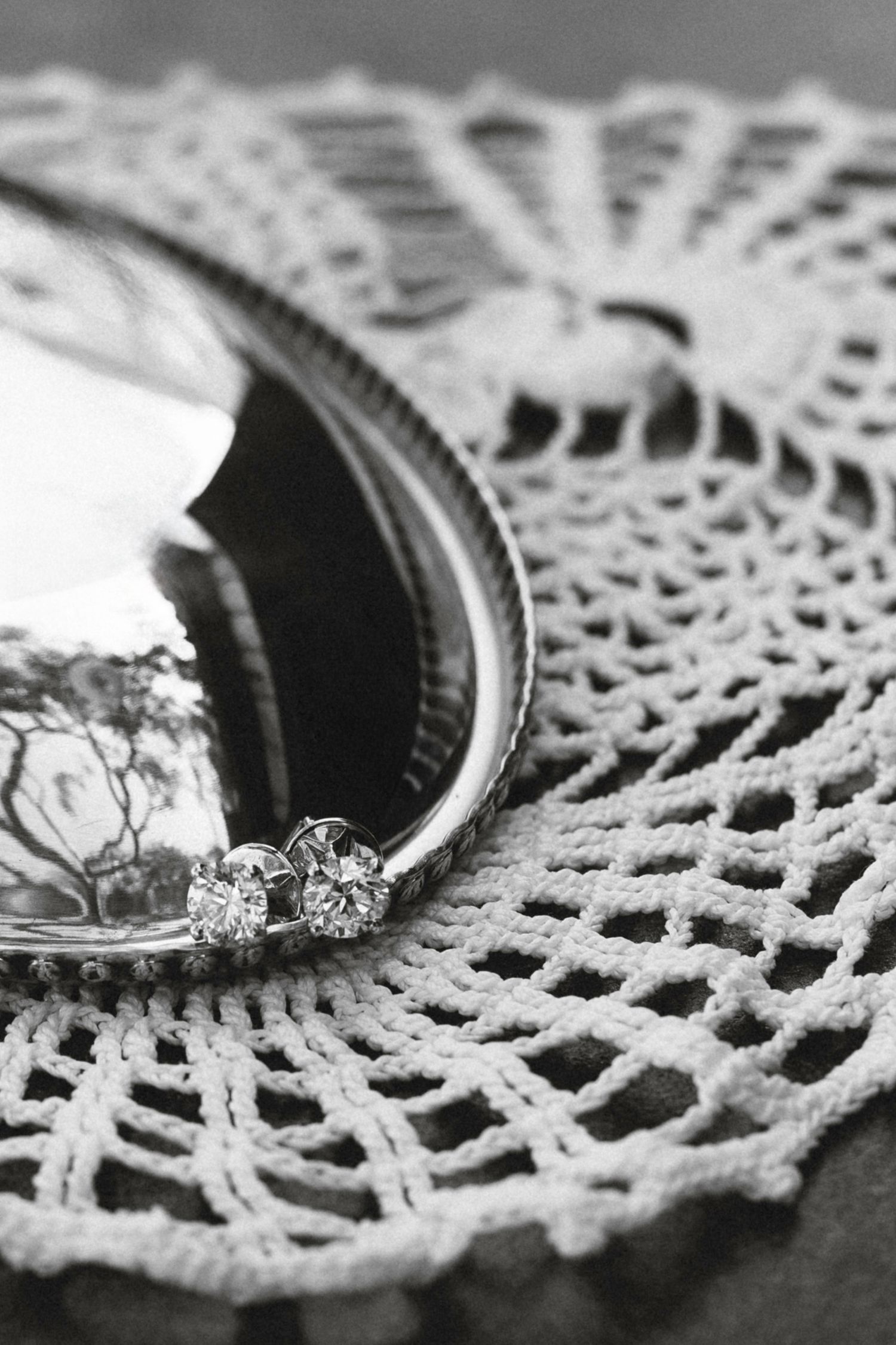 Delicate white lace doily pattern with decorative details in black and white macro photography.