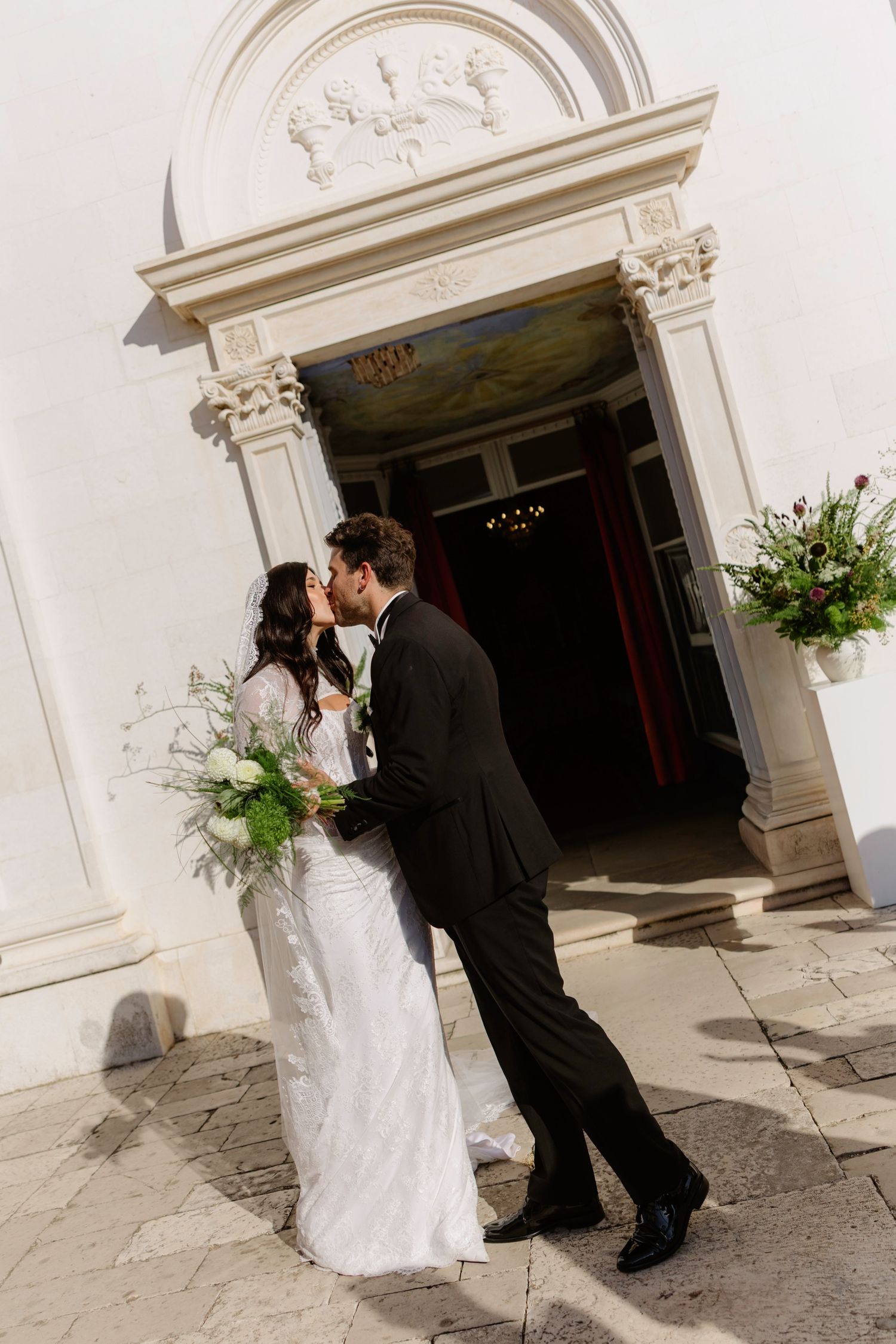 A romantic wedding scene captured in a series of photos showing a couple embracing outside an elegant white building, Hvar, Croatia
