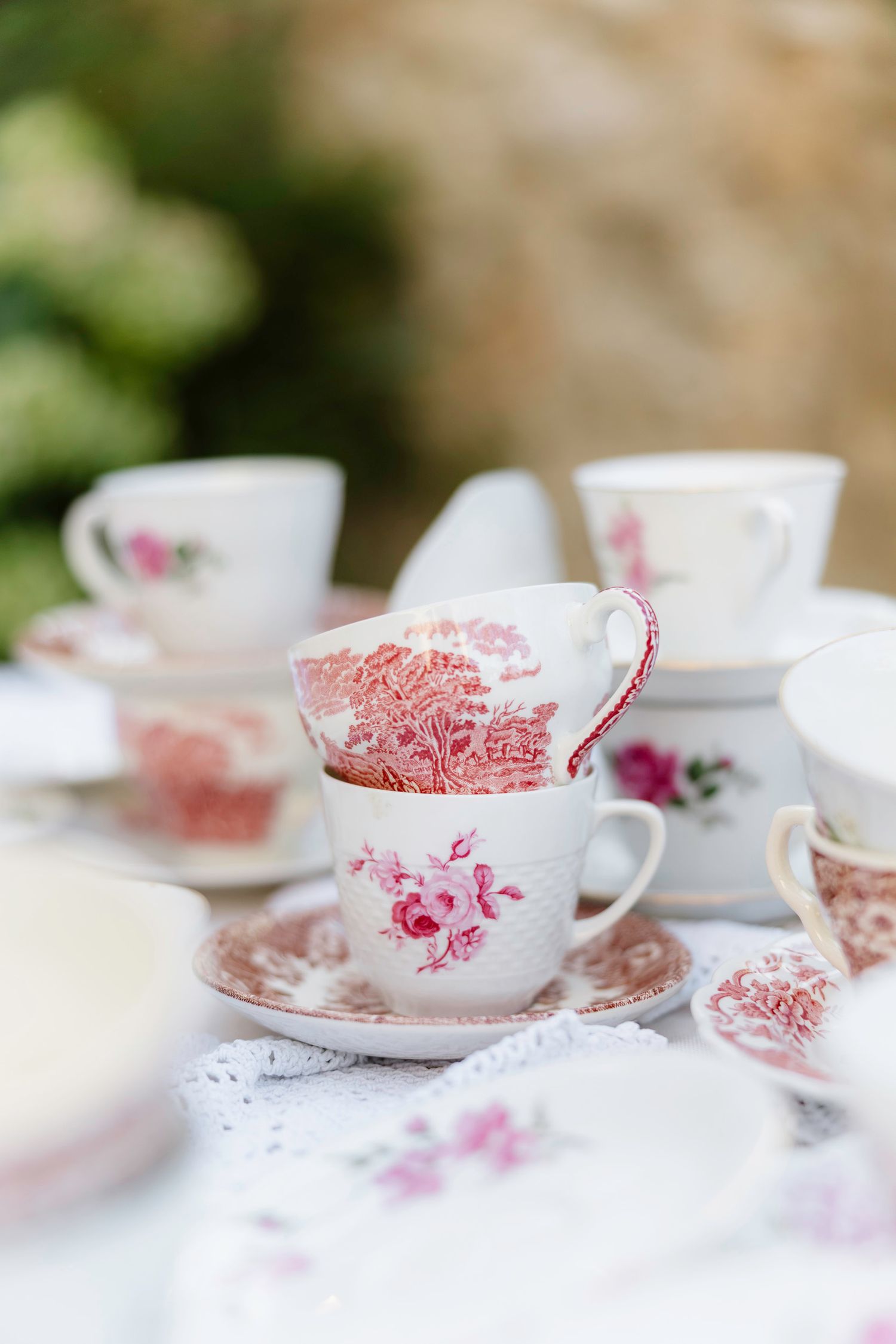 Vintage pink and white teacups with floral patterns arranged in a row on a white surface. Hvar, Croatia