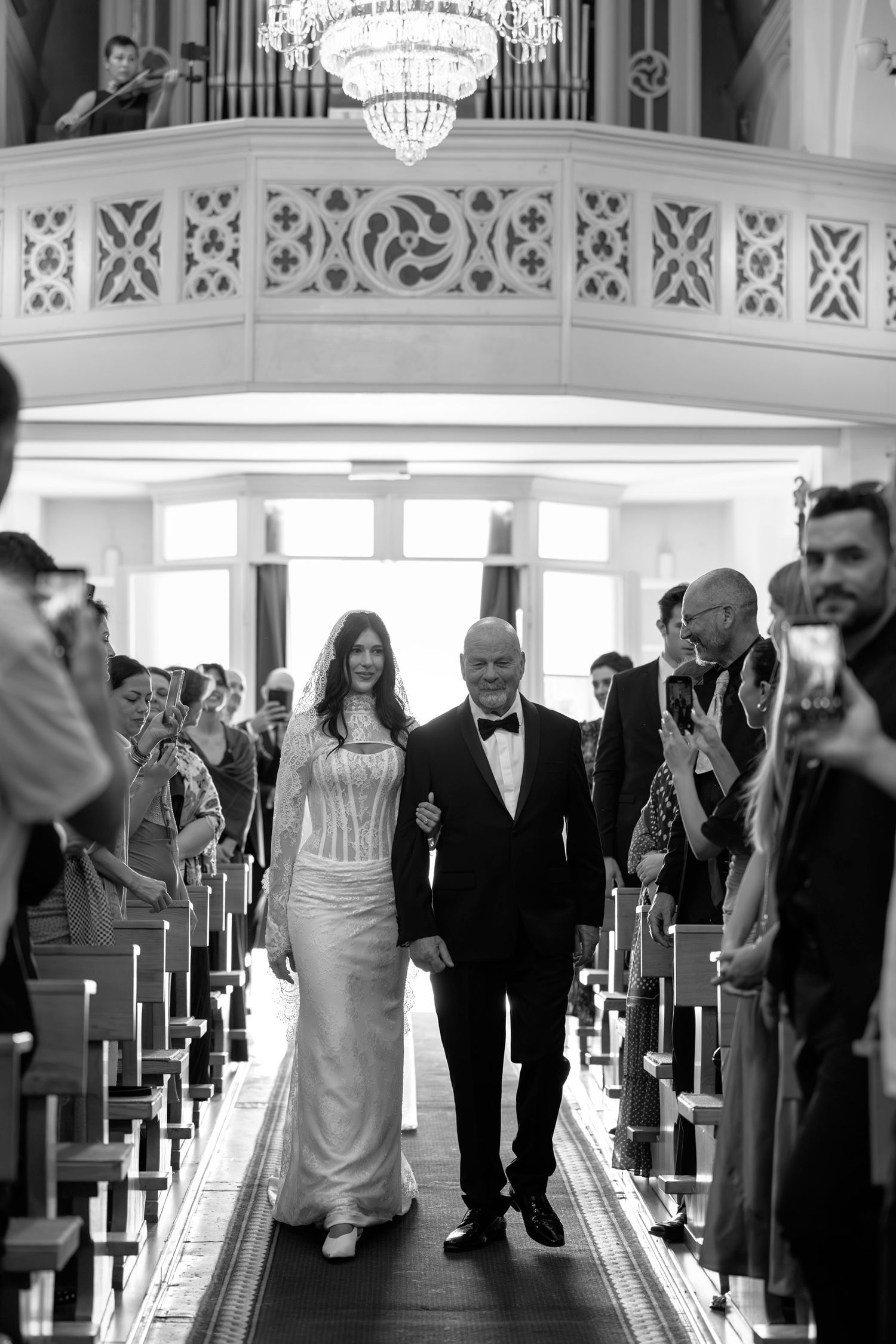 Black and white wedding ceremony processional in an elegant church setting.