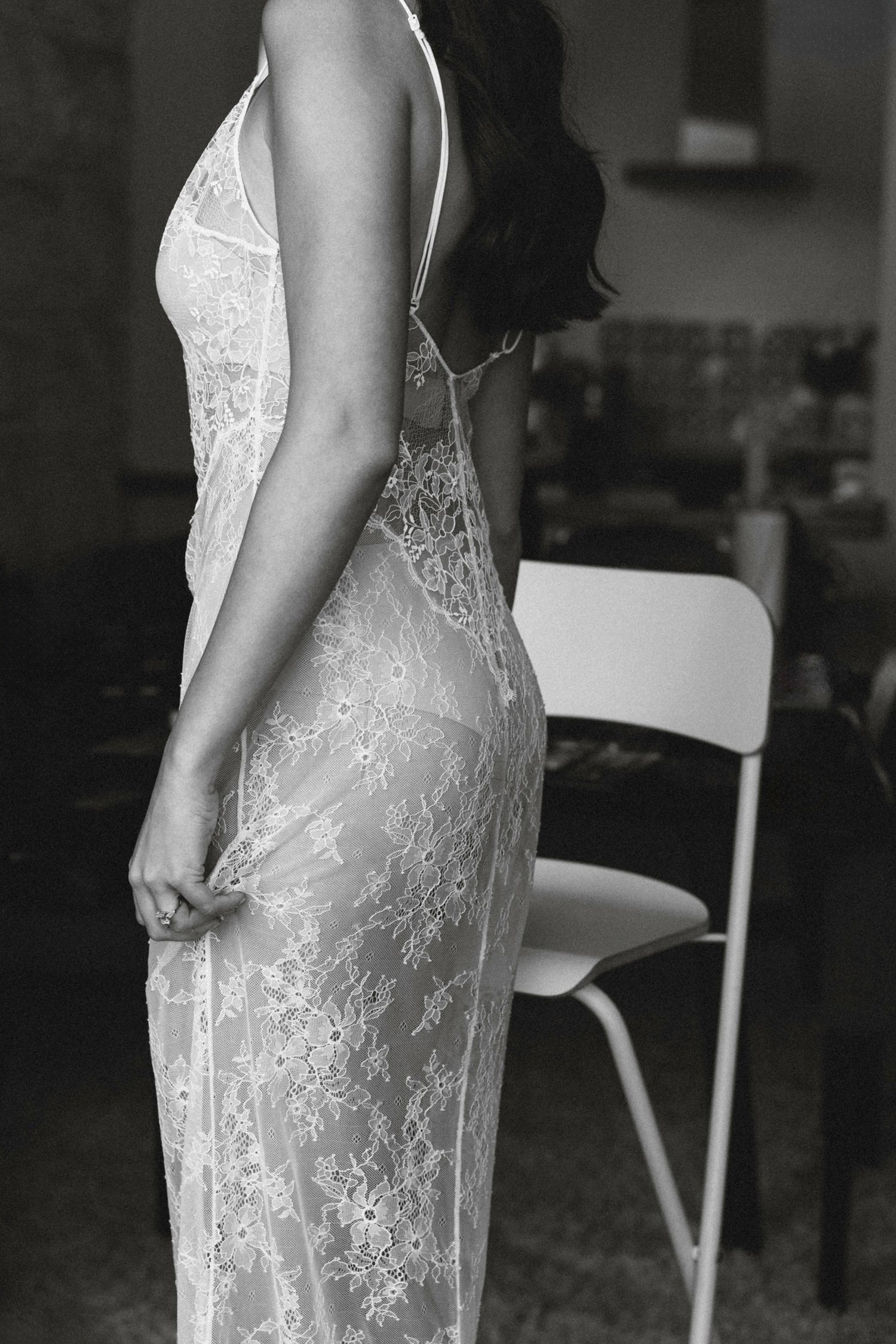 Close-up view of intricate white lace wedding dress details in black and white.