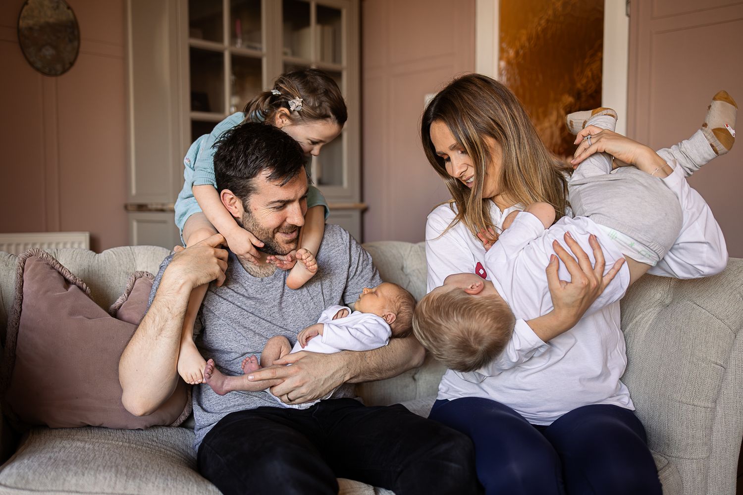 A cozy family moment on a sofa with a newborn baby.