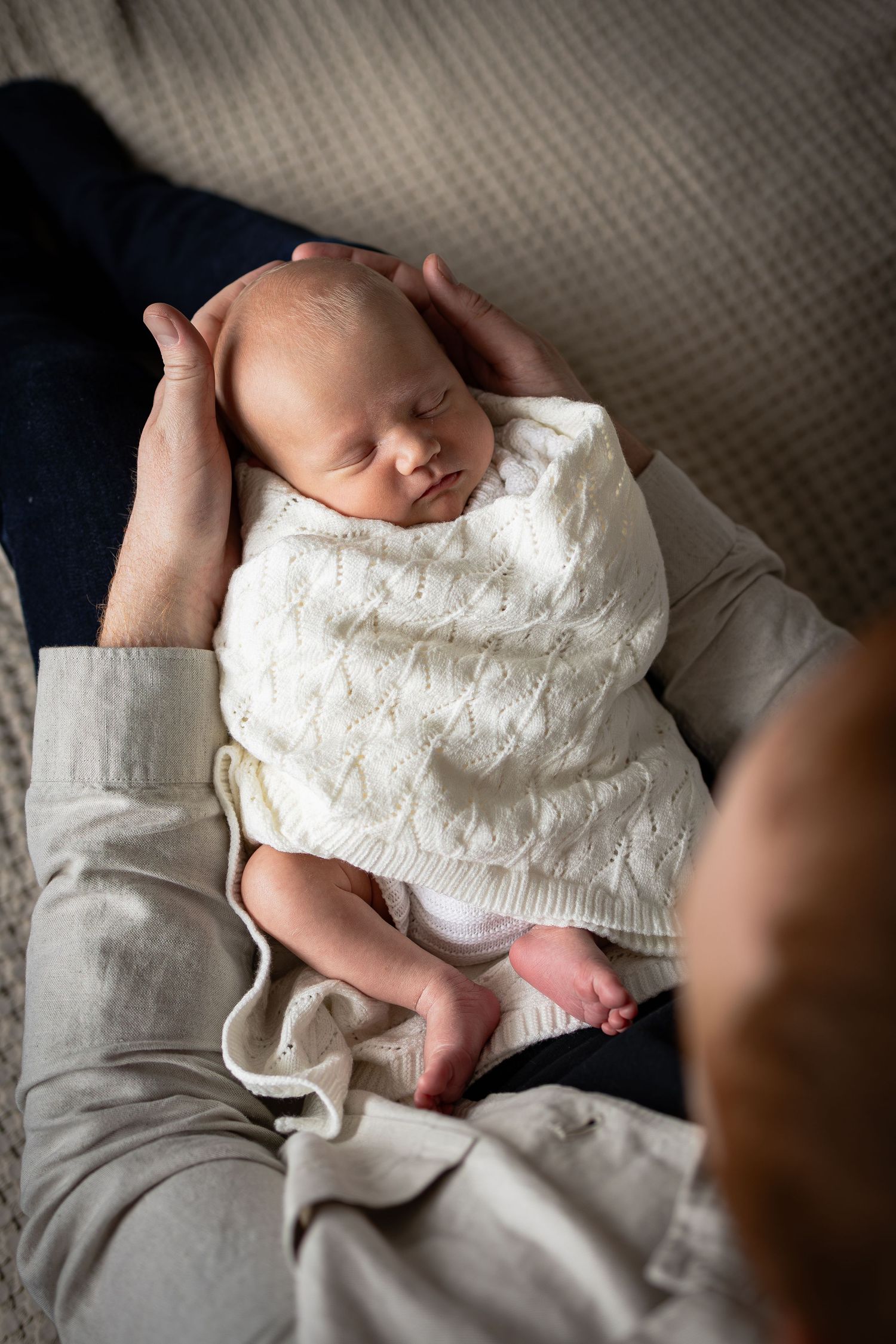 Portrait of Newborn baby being cradled by dad during at home newborn photoshoot in York