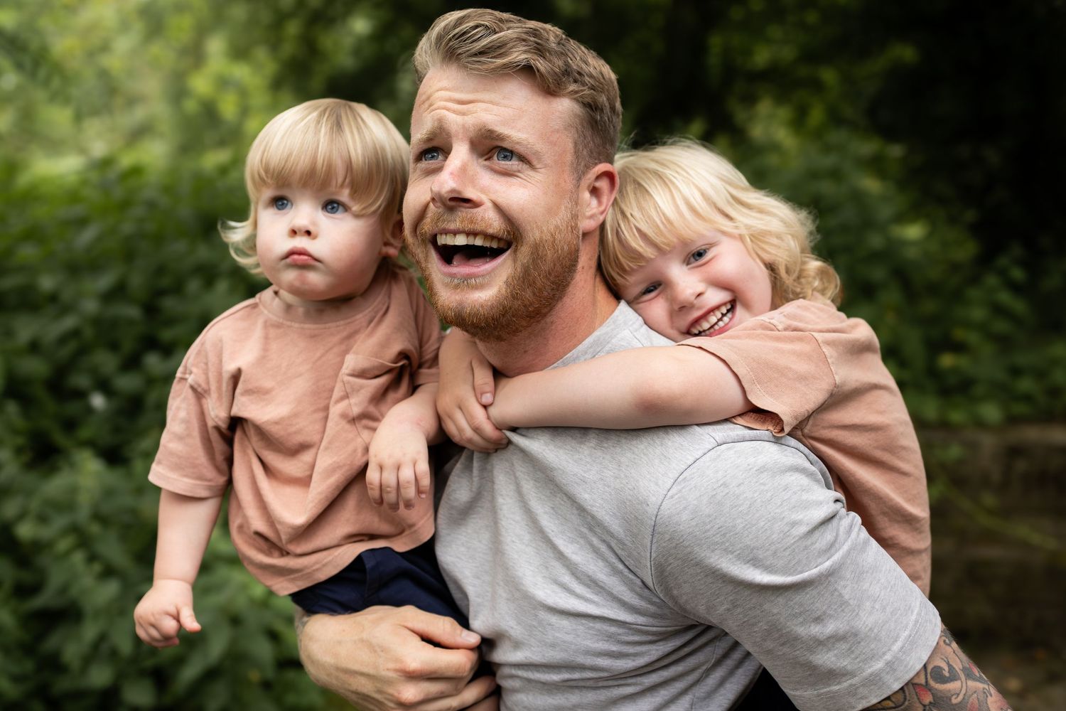 Playful family moment outdoors with matching brown and grey outfits.