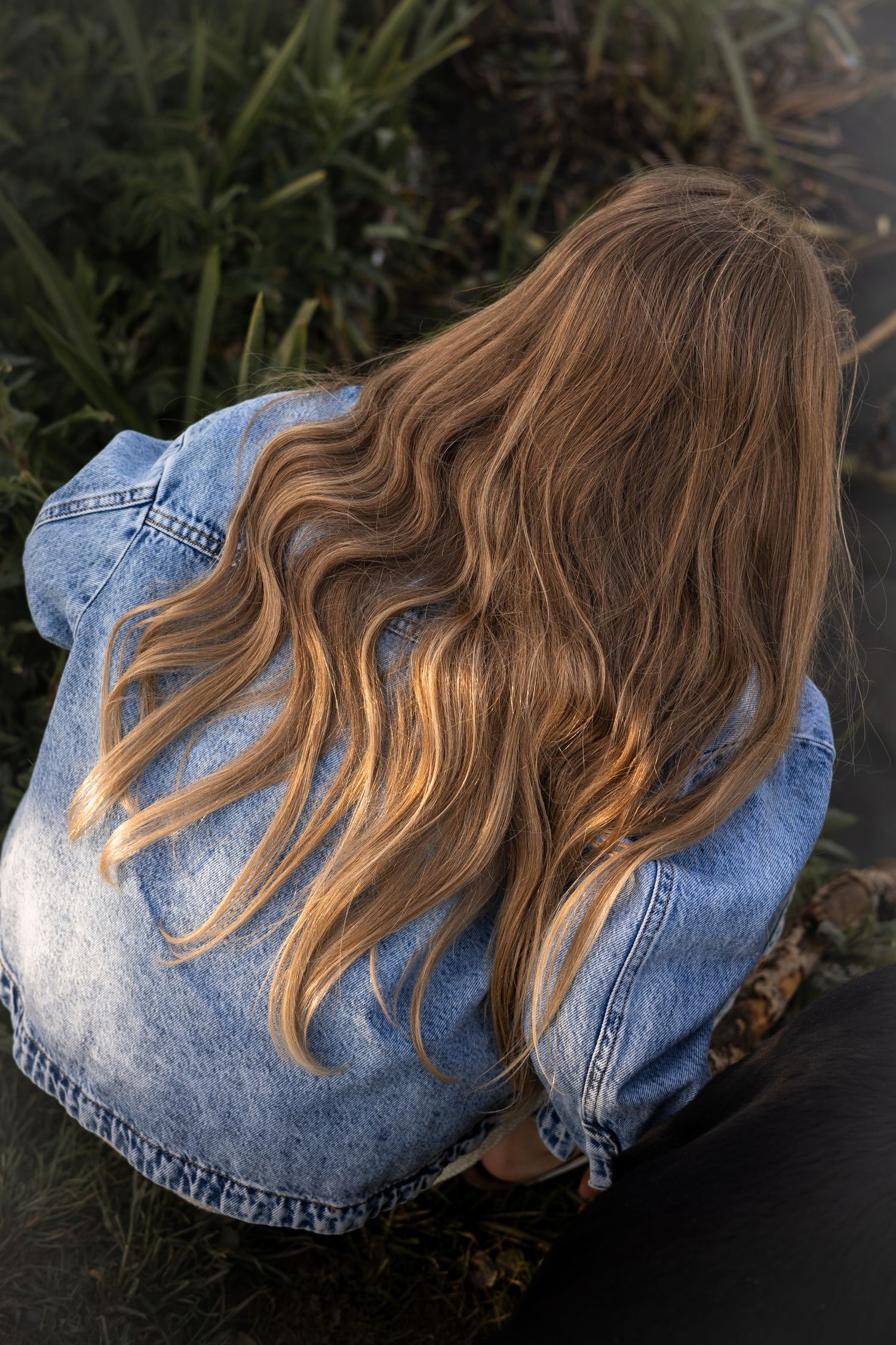 Seven sequential photos show long wavy brown and blonde hair cascading over a light blue denim jacket.