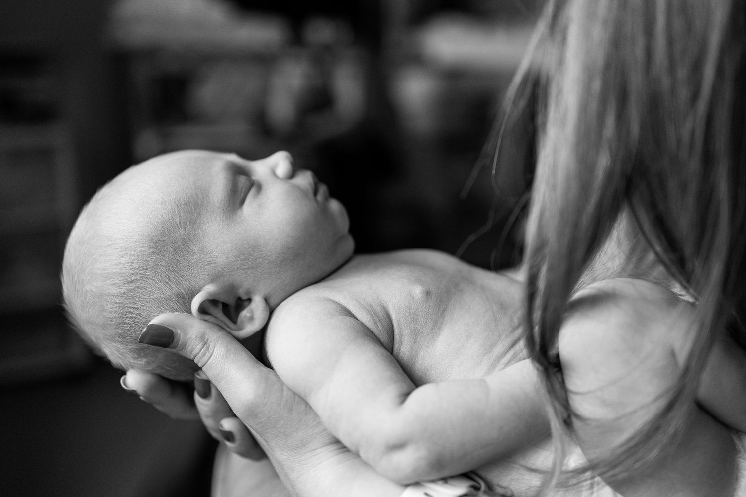 Side portrait of newborn baby asleep in mummy's hands during newborn photoshoot in York