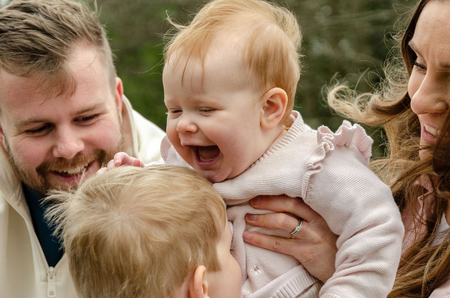 Happy family sharing a joyful moment of laughter outdoors.