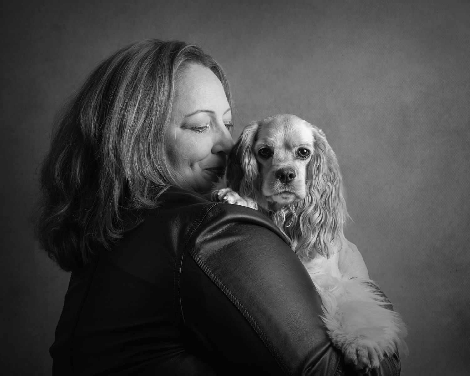 A series of black and white photographs showing tender moments between a person and their small white dog.