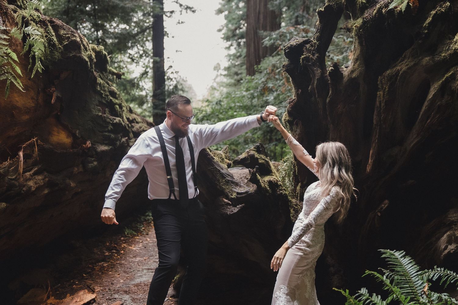 Bride and groom dancing together in a lush forest canyon during their outdoor elopement wedding ceremony.