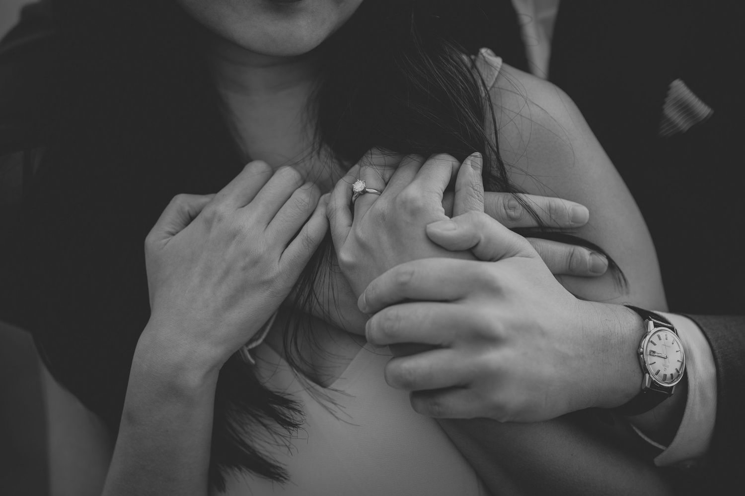 Close up of hands embracing in intimate black and white portrait.
