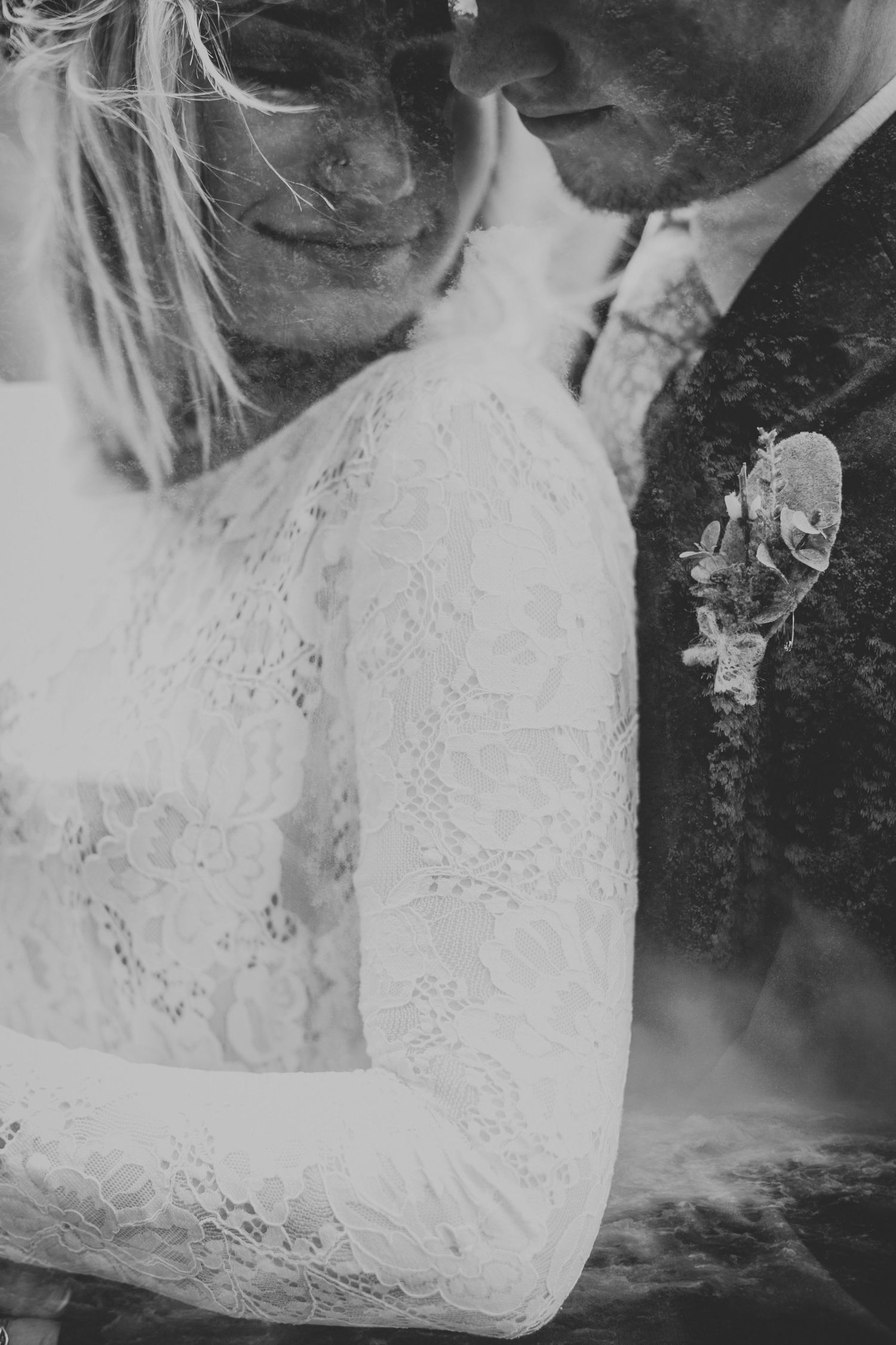 Close-up detail of delicate lace wedding dress and formal attire in black and white.
