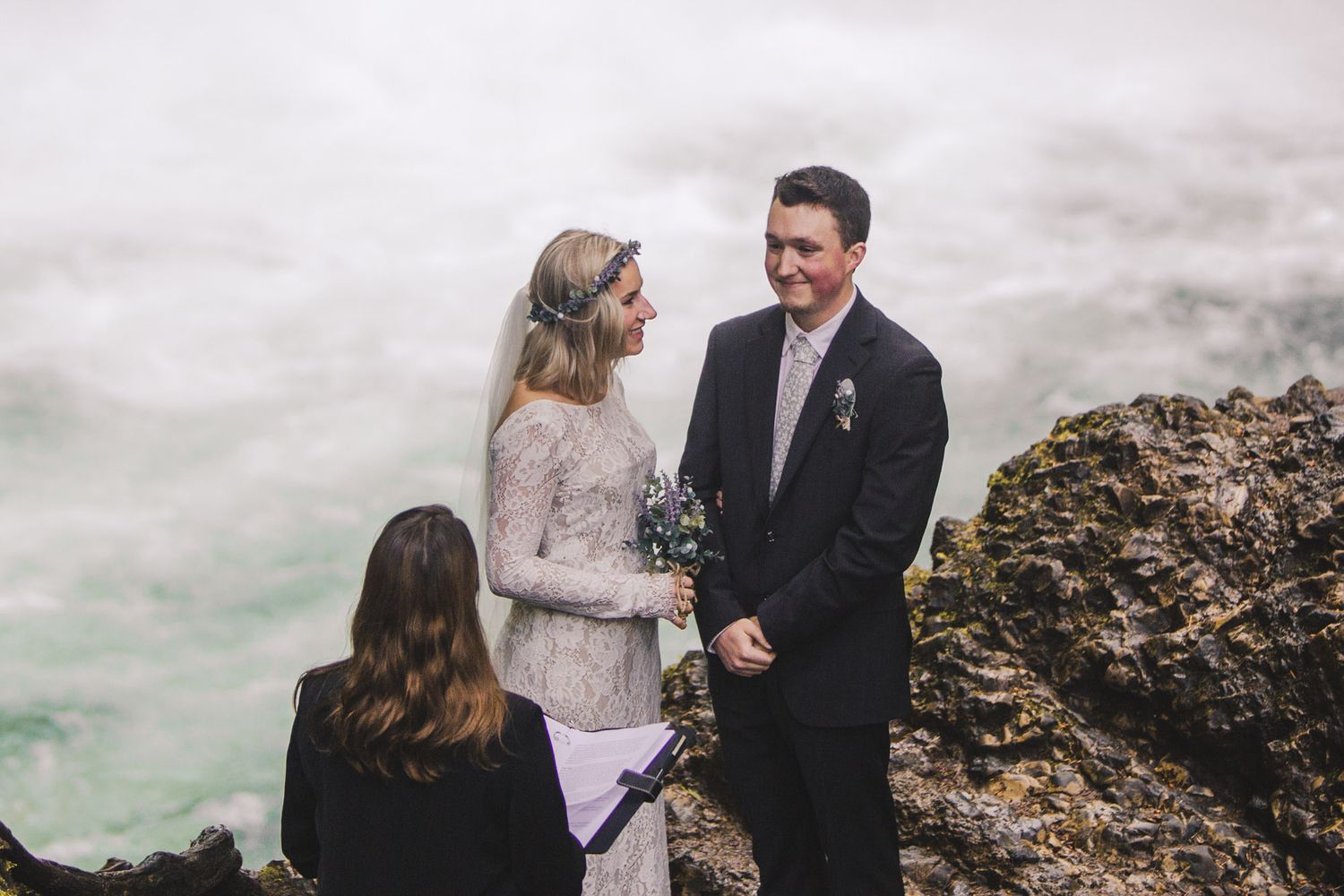 A couple exchanges vows during their waterfall elopement ceremony.