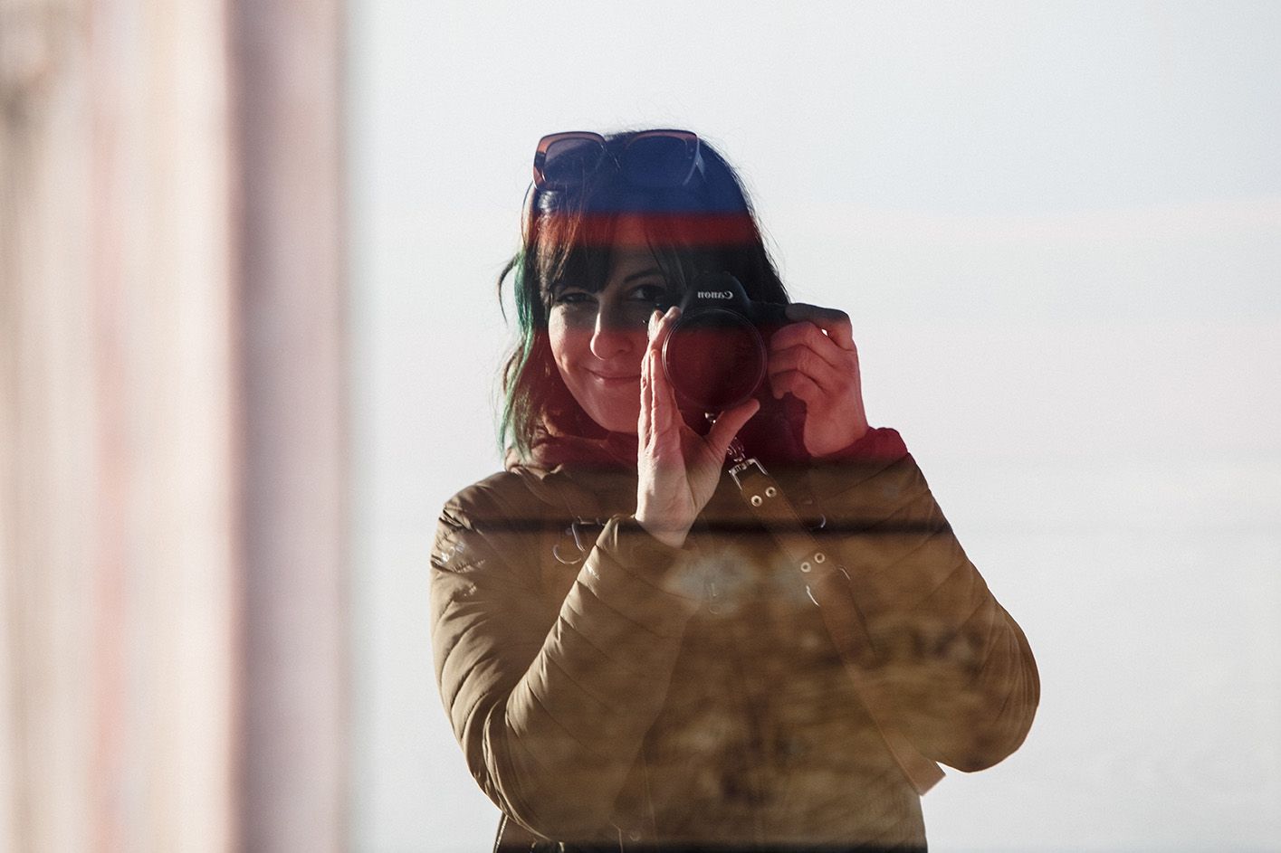 the photographer takes a photo of the reflection in a window during an elopement on Oregon's mount hood.