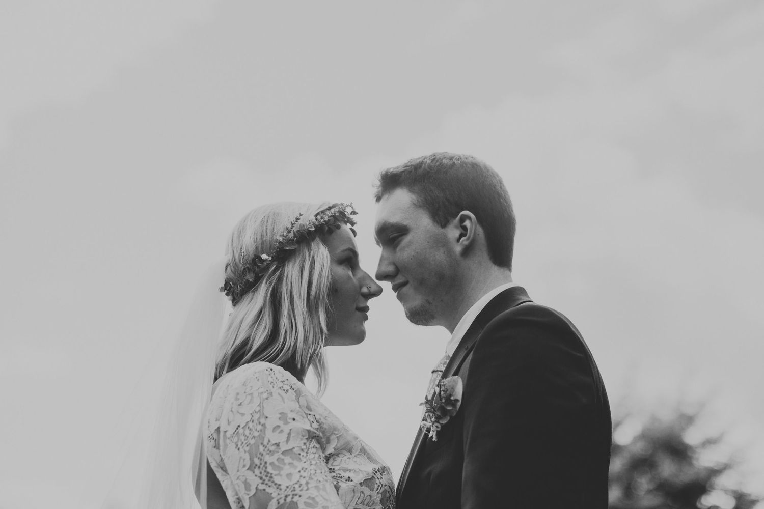 An intimate black and white portrait of a wedding couple with soft romantic lighting.