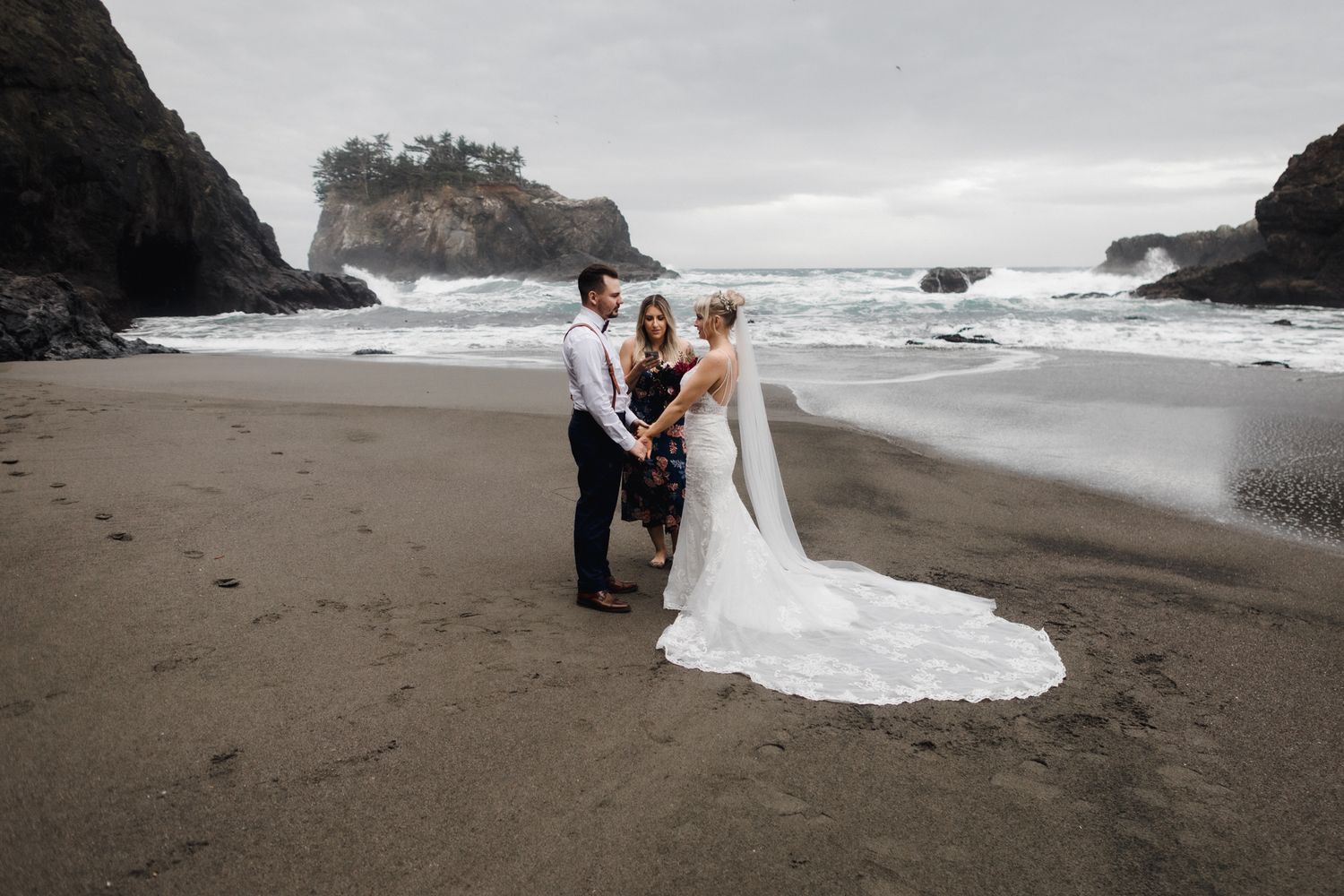 A beach wedding ceremony set against dramatic coastal cliffs and stormy ocean waves.