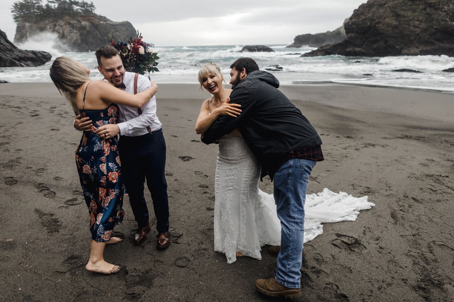 Wedding photographers capturing moments during a beach ceremony with dramatic coastal scenery.