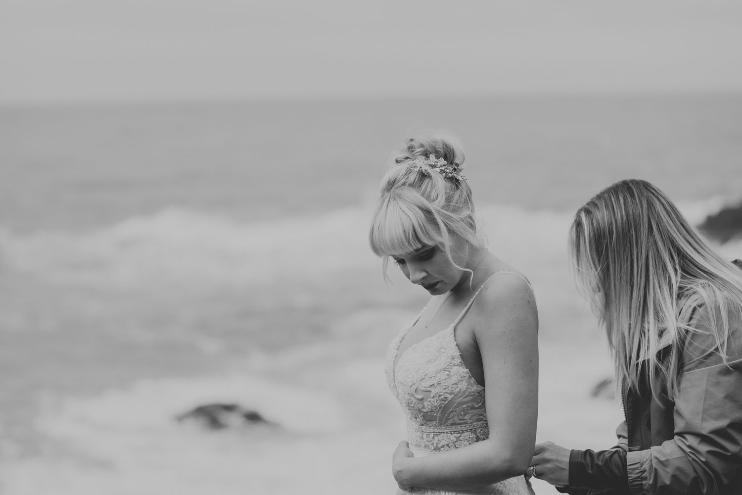Intimate moment captured in black and white against misty coastal backdrop.