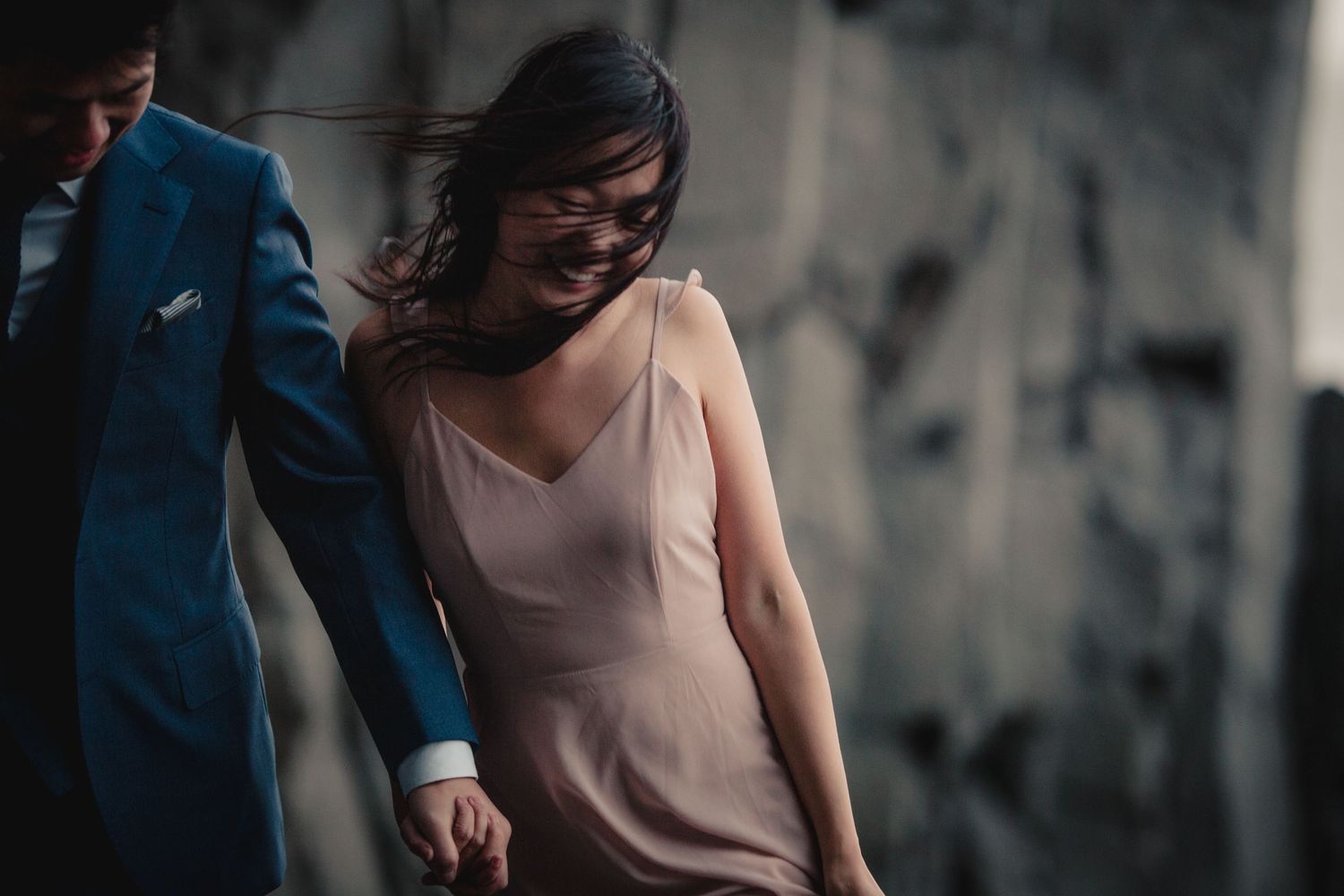 A couple laughs together while wearing formal attire.