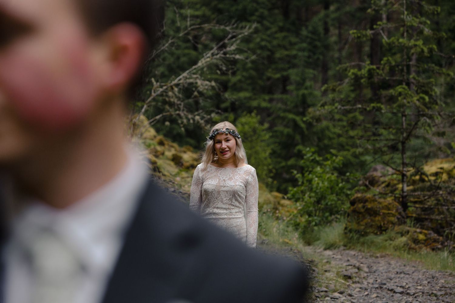 A dramatic forest wedding photo with selective focus creating depth.