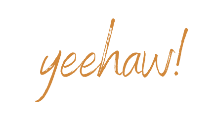 Handwritten cursive text reading yeehaw in warm golden orange brushstroke lettering on white background.