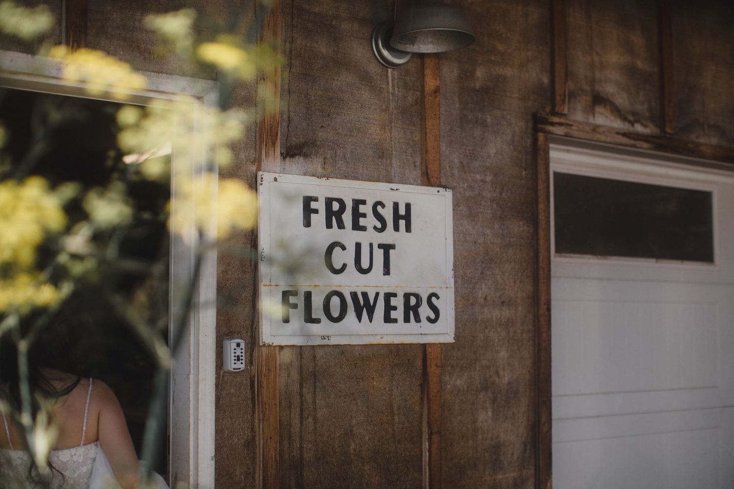 Vintage fresh cut flowers sign on a rustic wooden door at a flower shop.