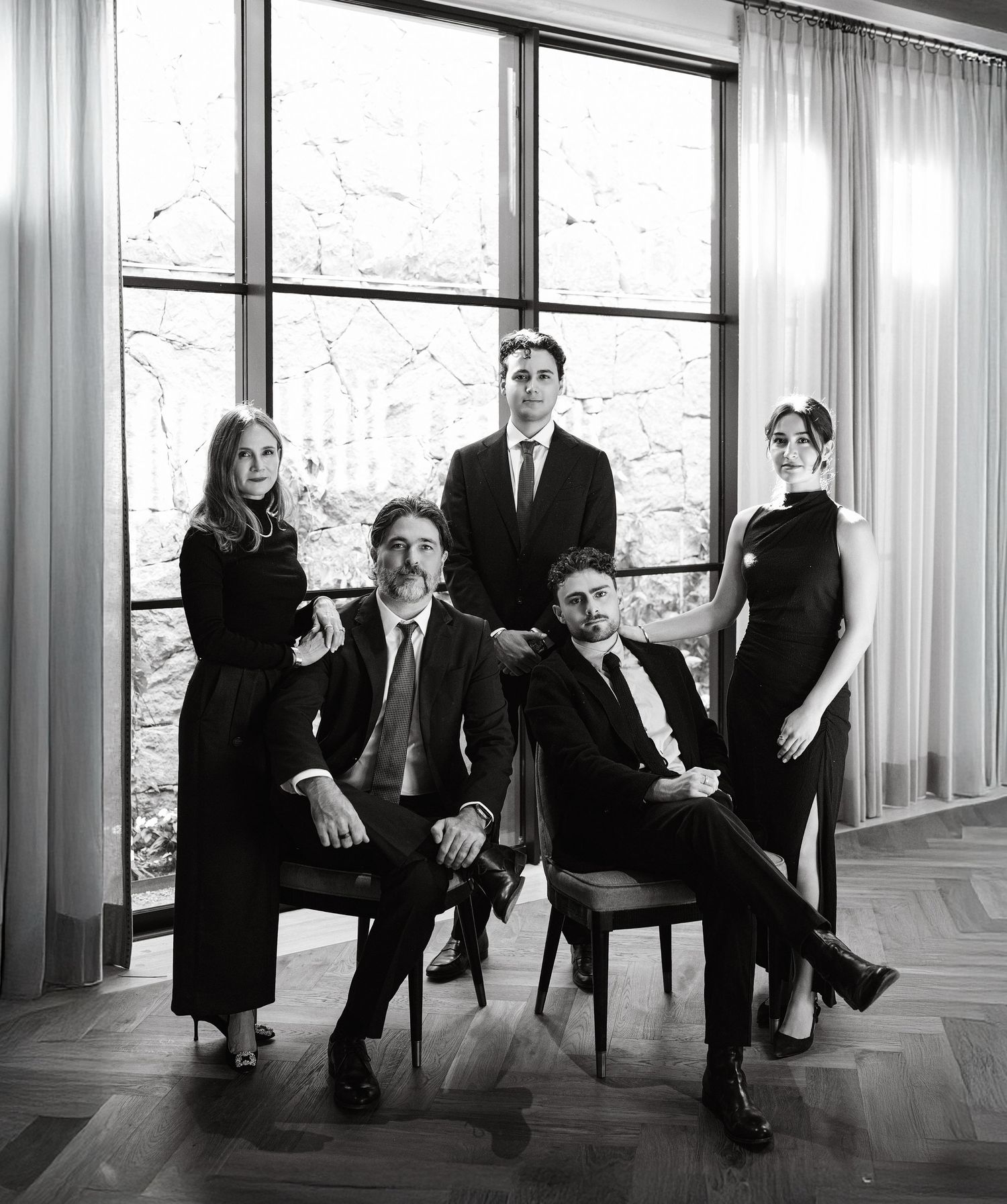 A panoramic black and white photo of business professionals seated in a modern office setting with large windows.