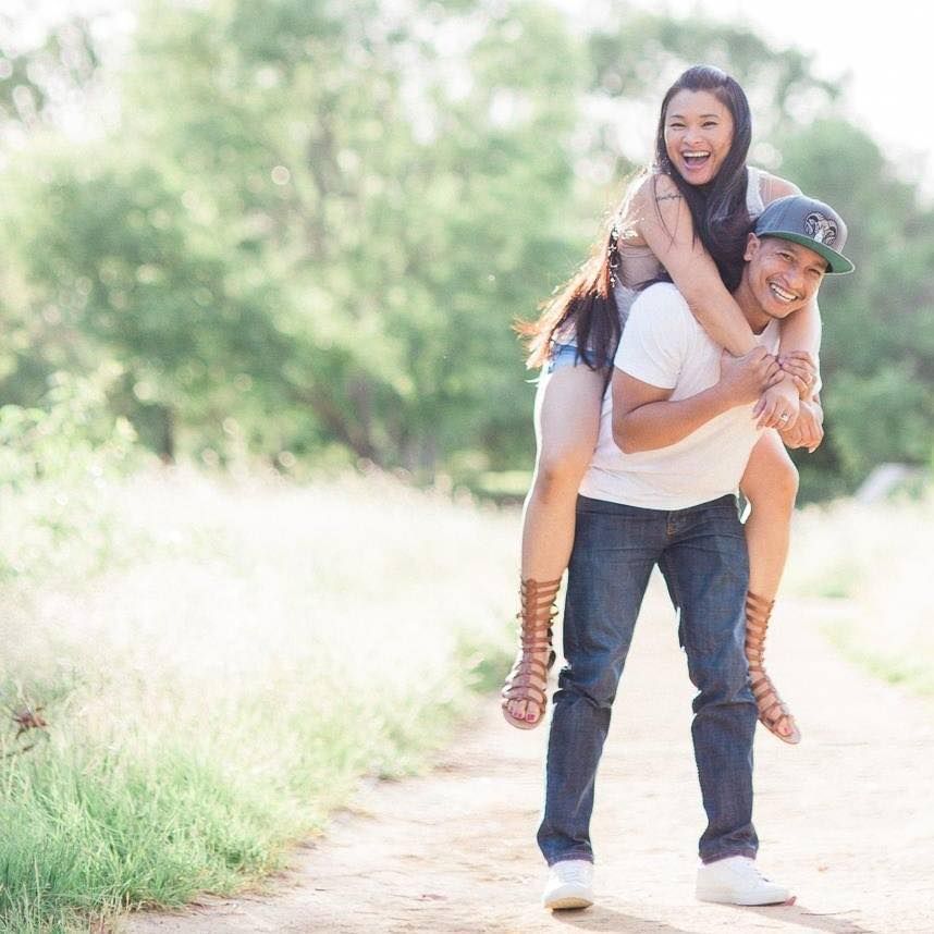A playful piggyback ride moment captured on a sunlit nature trail.