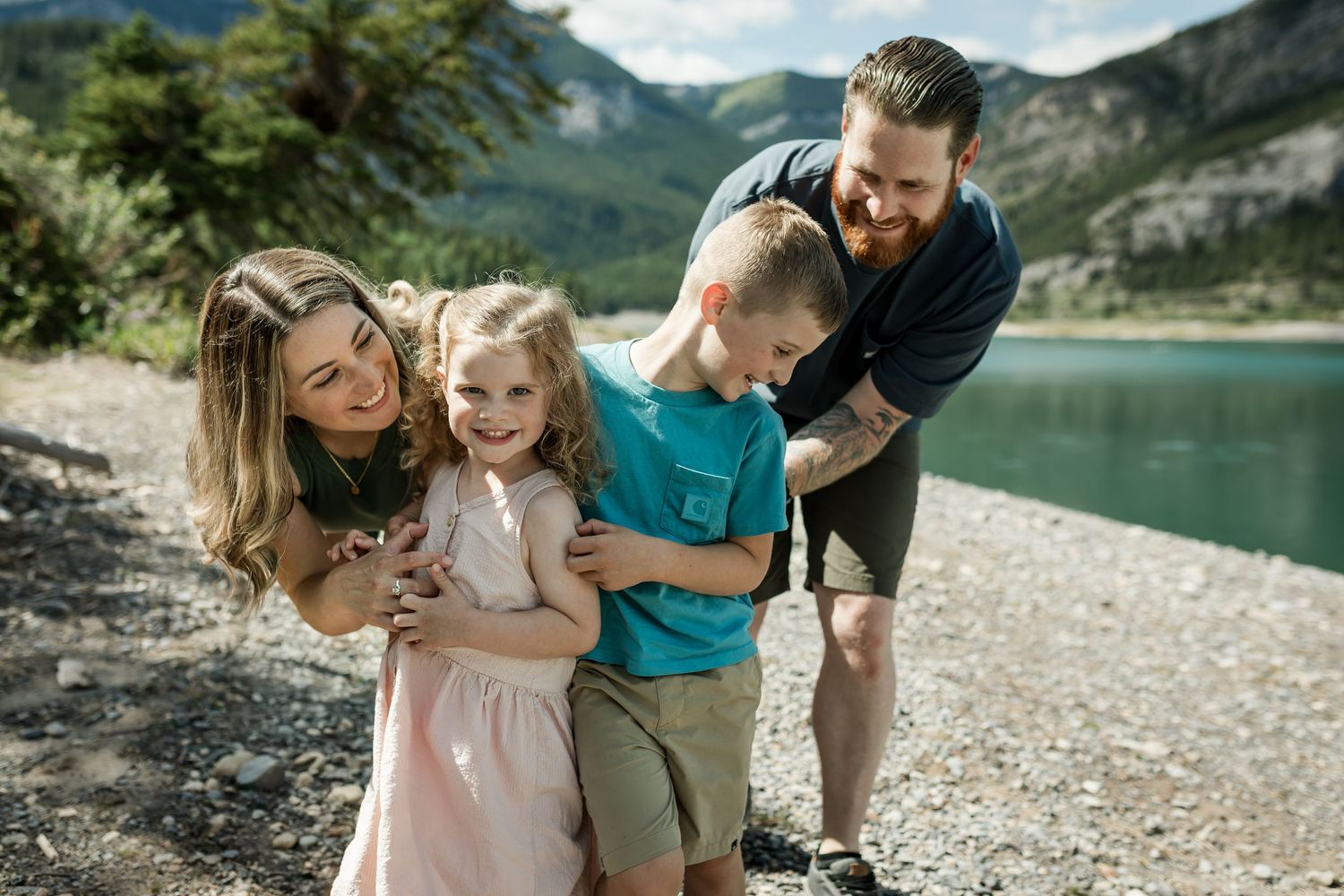 Calgary family laughing together during a lifestyle family photography session at Barrier Lake in the Kananaskis mountains.