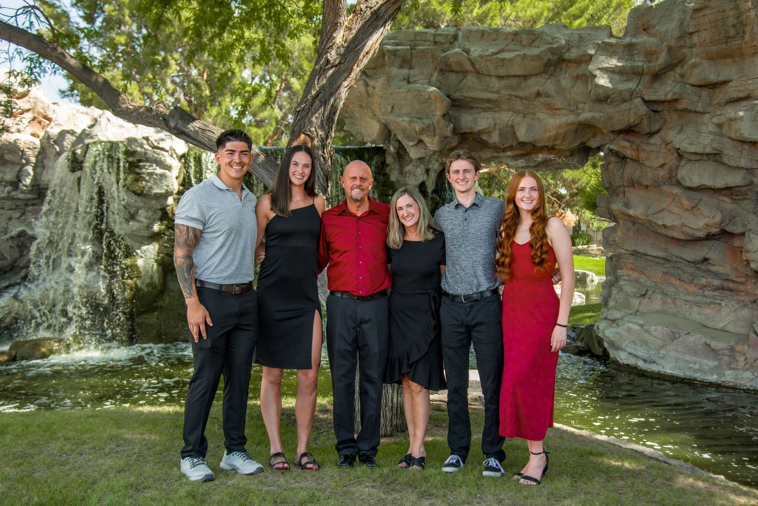 Group photo of family members in formal attire against natural rock formation backdrop.