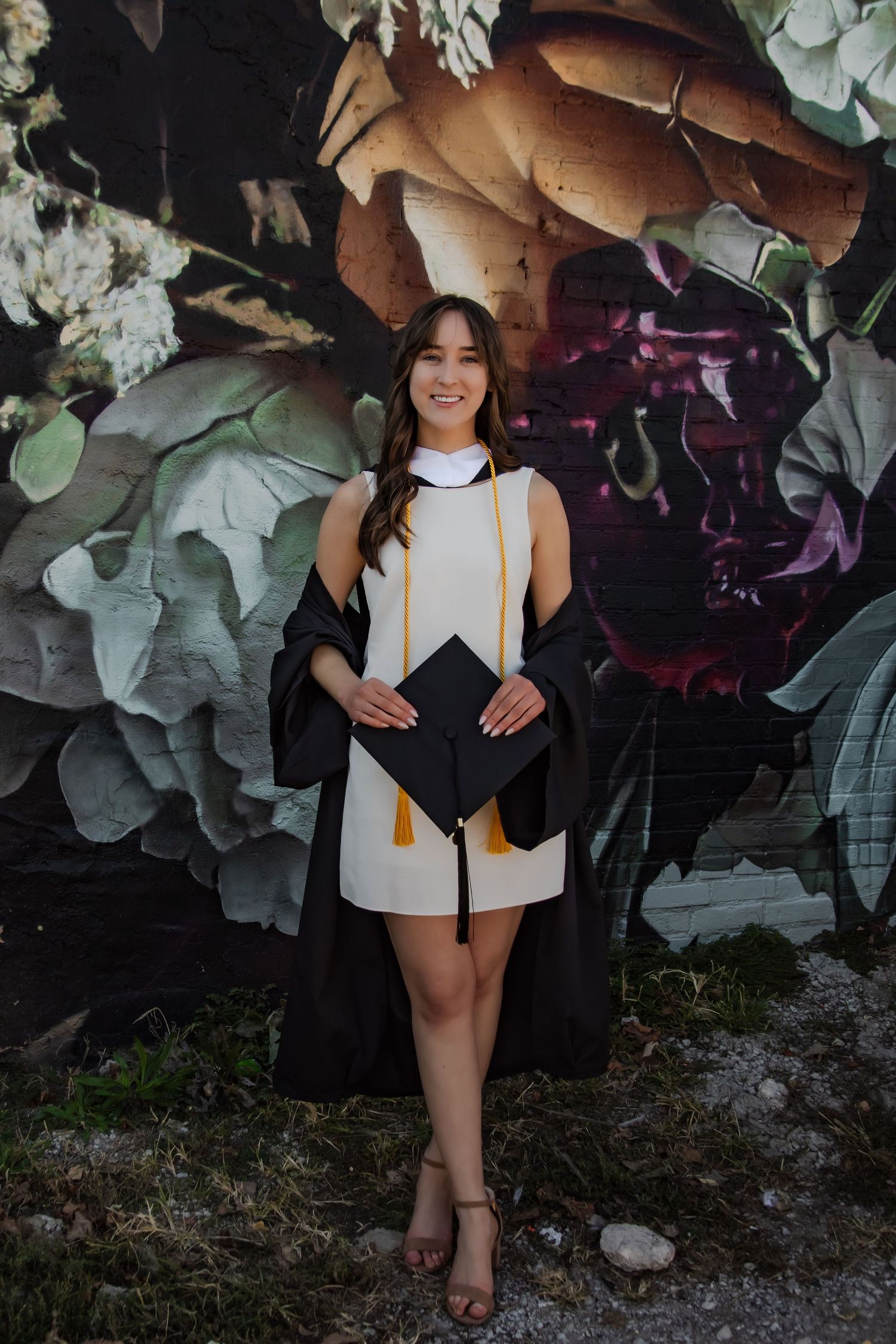 Graduation photos against colorful floral wall art background.