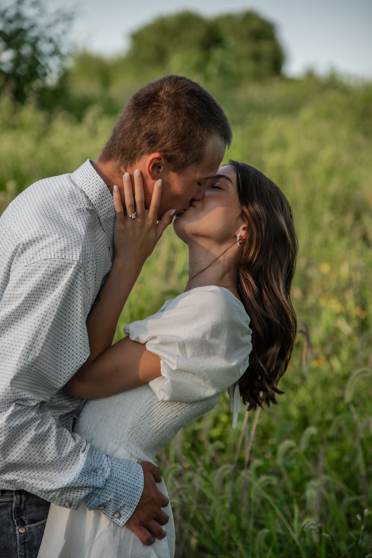 A romantic outdoor photo sequence showing a tender embrace and kiss in a field of wildflowers on a sunny day.