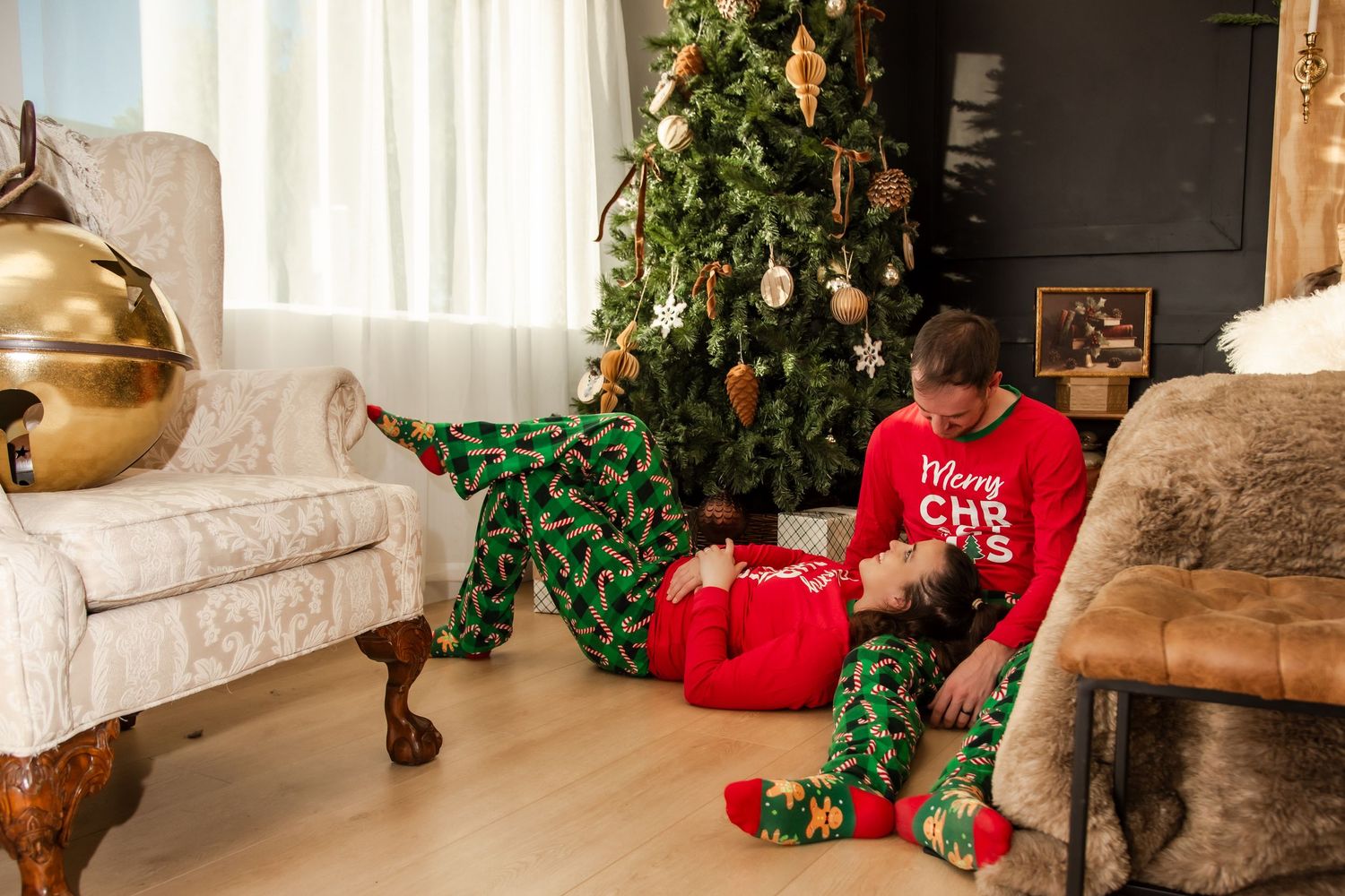 A cozy living room decorated for Christmas with stockings hung on the wall and festive greenery throughout.
