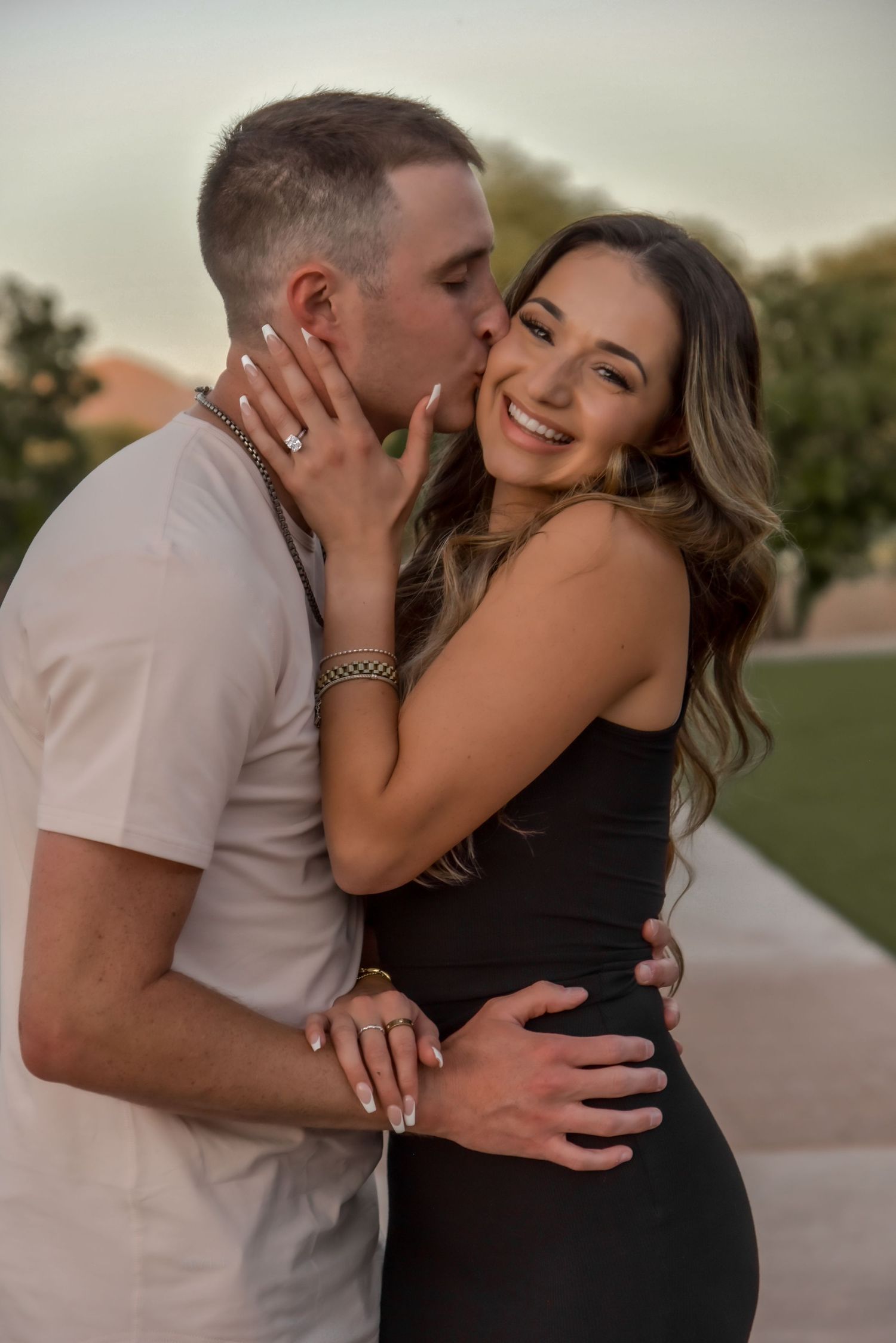 A tender moment captured between a couple during an engagement photo session at dusk.