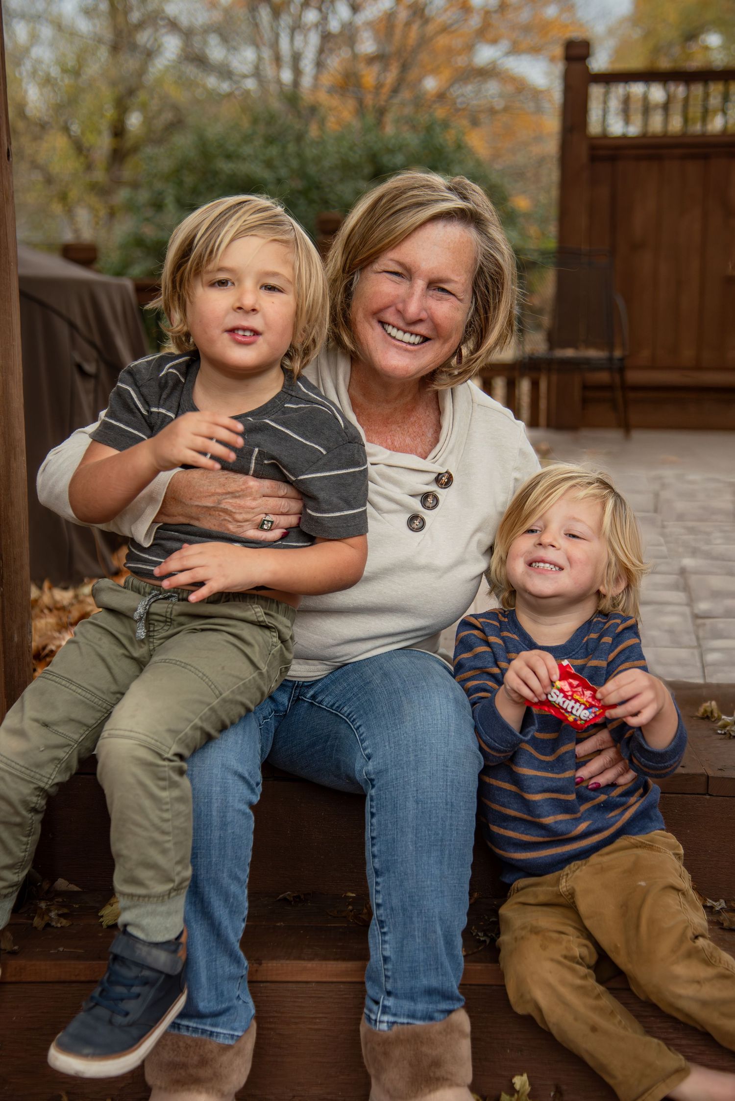 Candid playful moments captured on a wooden deck during a family photo session.