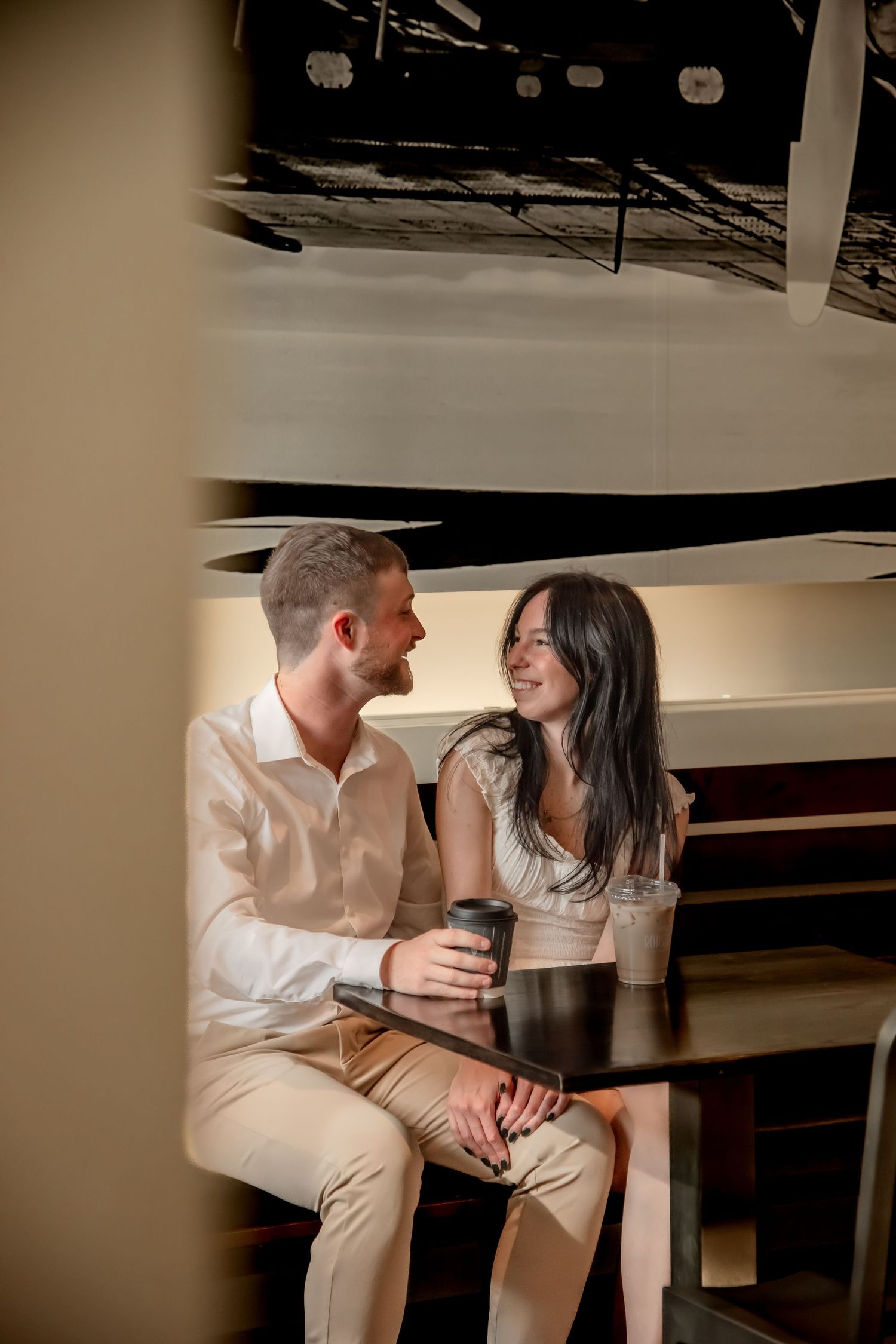 A romantic couple shares an intimate moment while sitting together at a bar counter.
