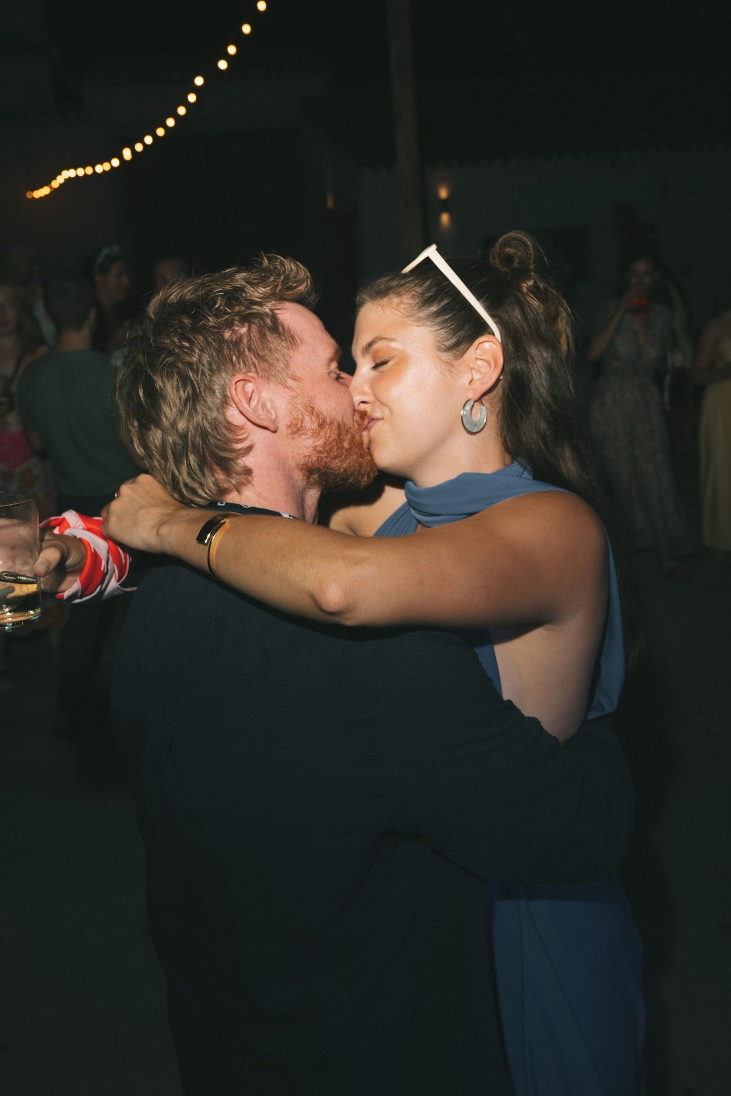 Couples dancing closely together at a dimly lit evening reception.