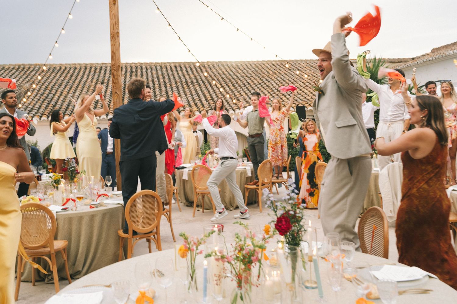Outdoor wedding reception with string lights and decorated tables at a Spanish venue.