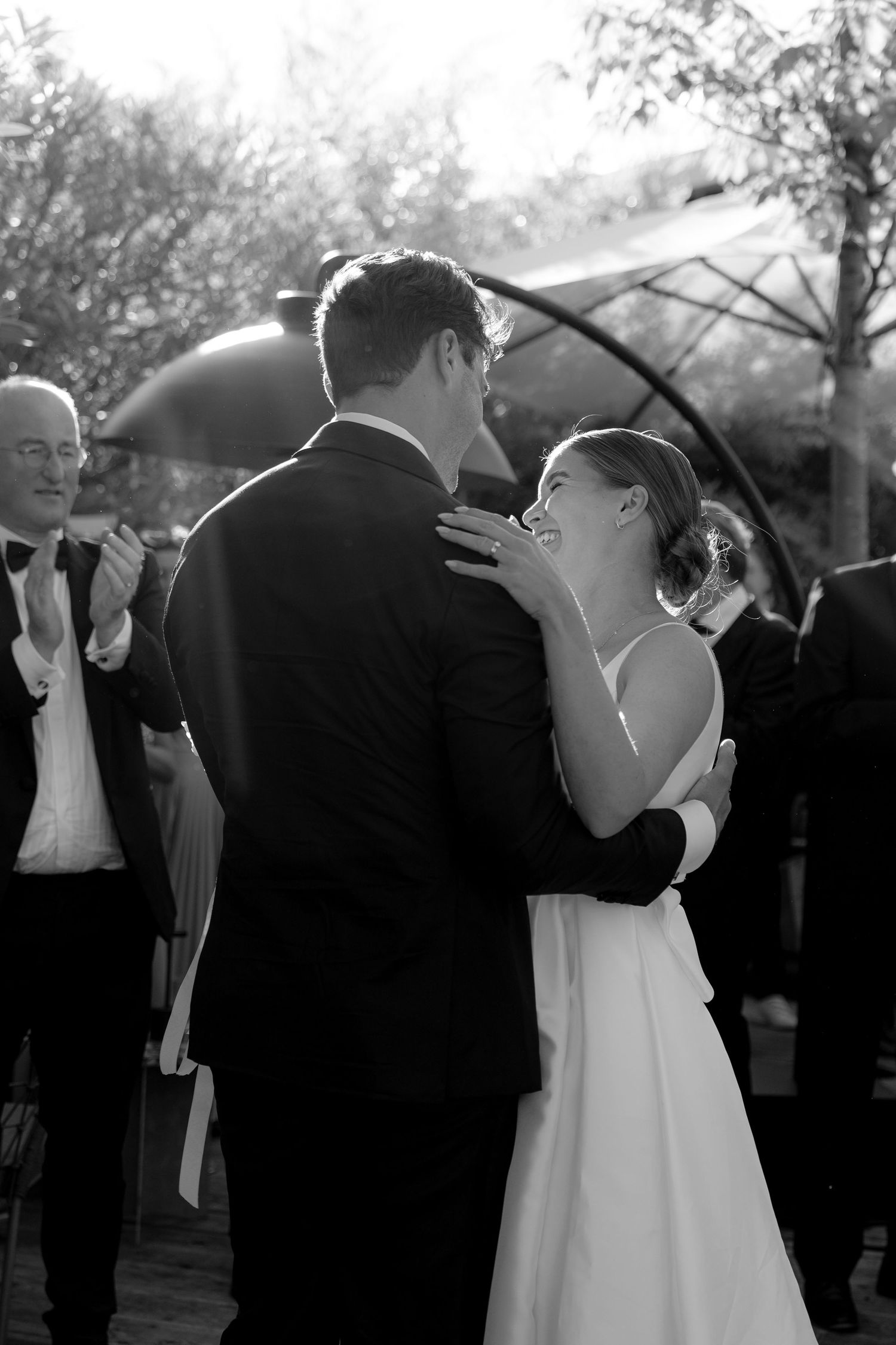 A couple sharing their first dance at an outdoor wedding reception.