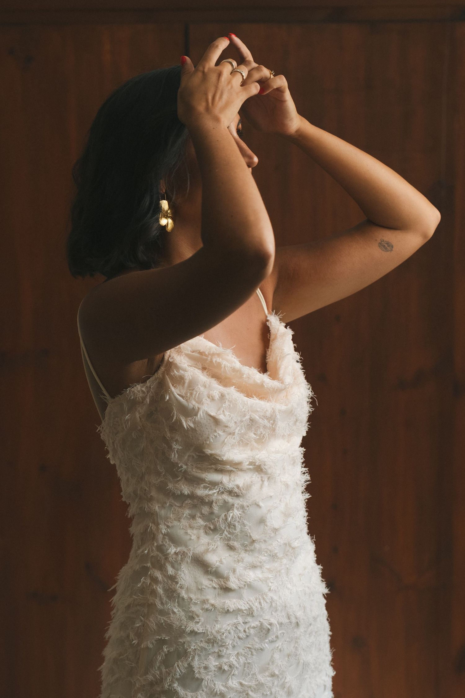Artistic bridal portrait highlighting the layered texture of a white wedding dress.