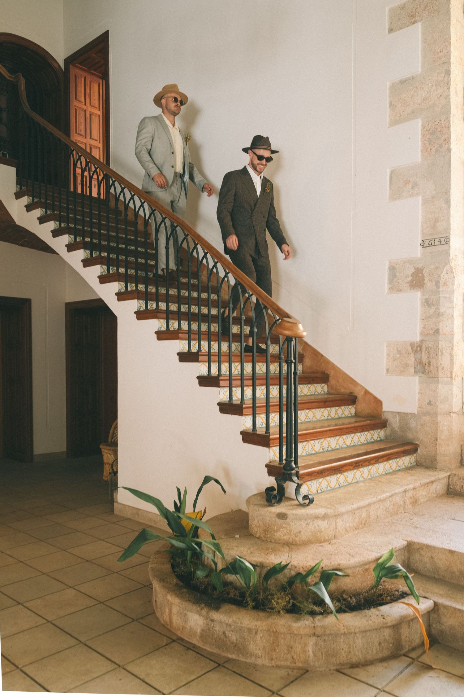 Sequential photos showing movement down an elegant stone staircase with wooden railings.