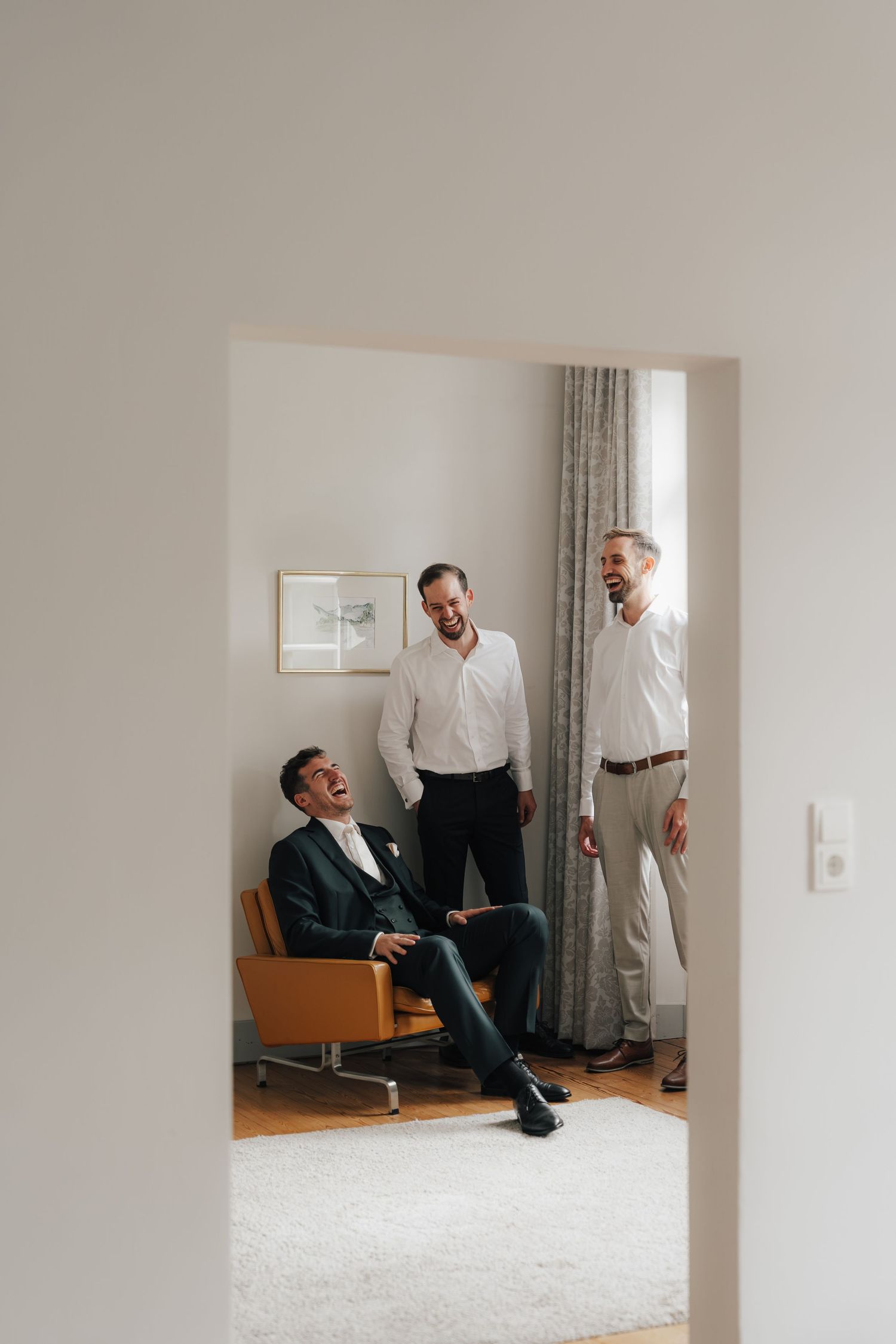 Sequence of photos showing a person in formal attire lounging in a bright minimal room.