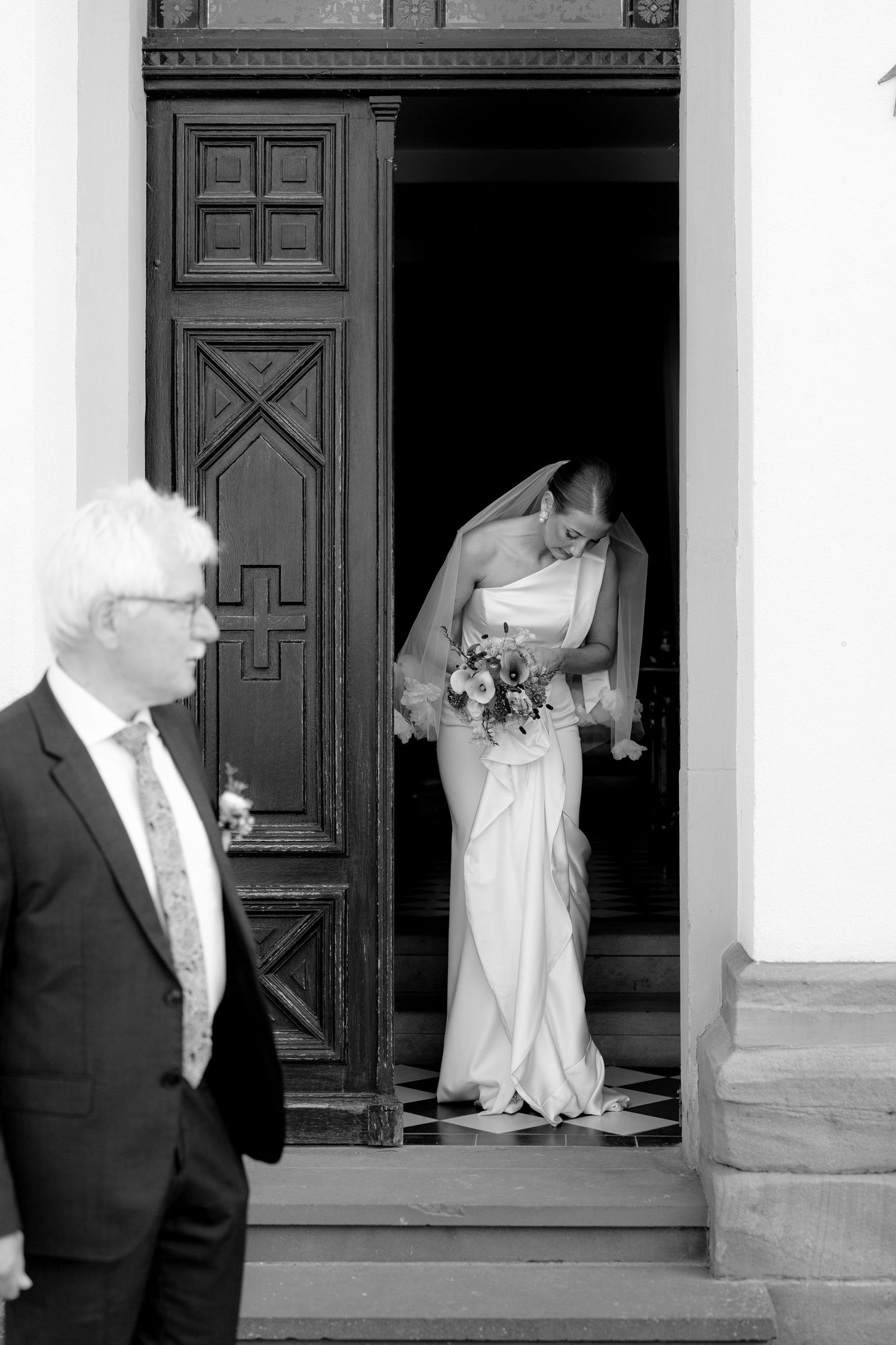 Black and white wedding sequence showing moments near ornate church doors.