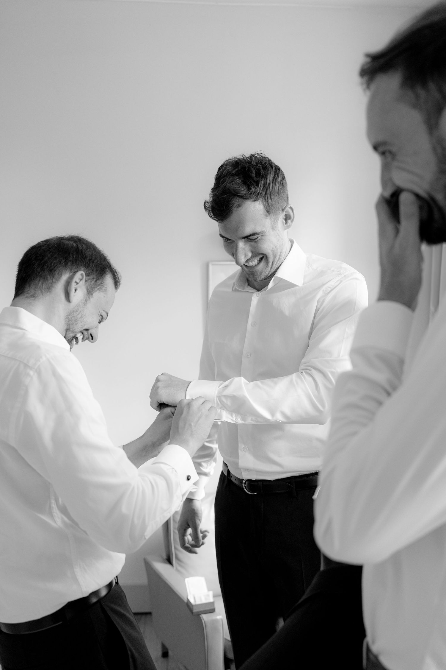 Men in formal white shirts share a lighthearted moment together.