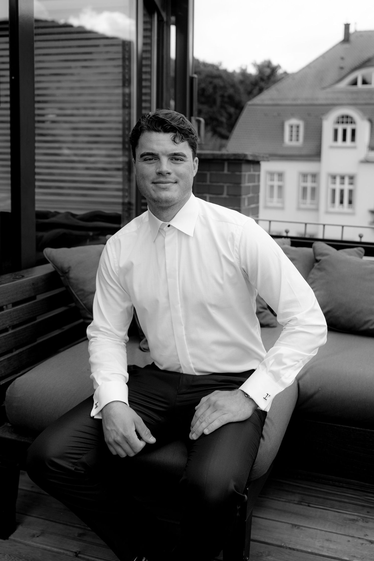 Black and white portrait series showing a person in a white dress shirt seated on a dark couch.